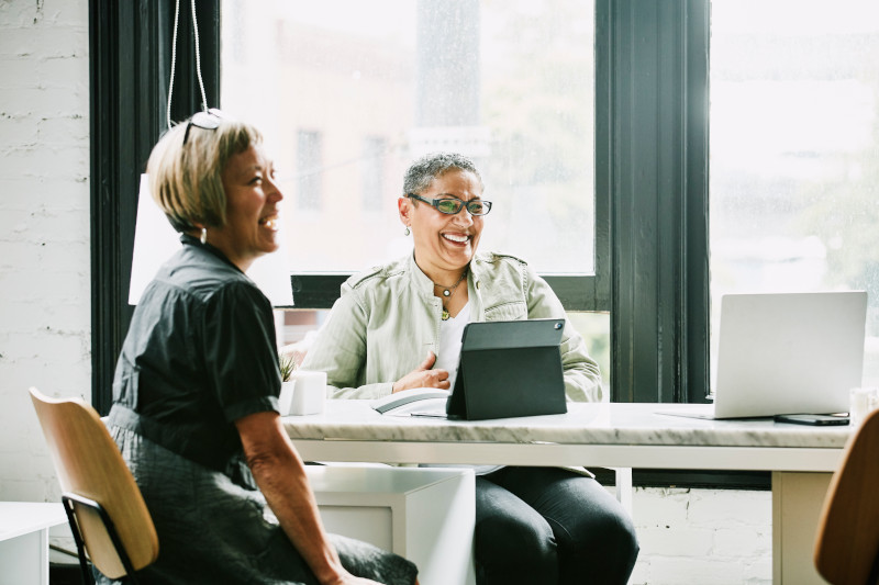 Laughing mature female business partners in meeting in office