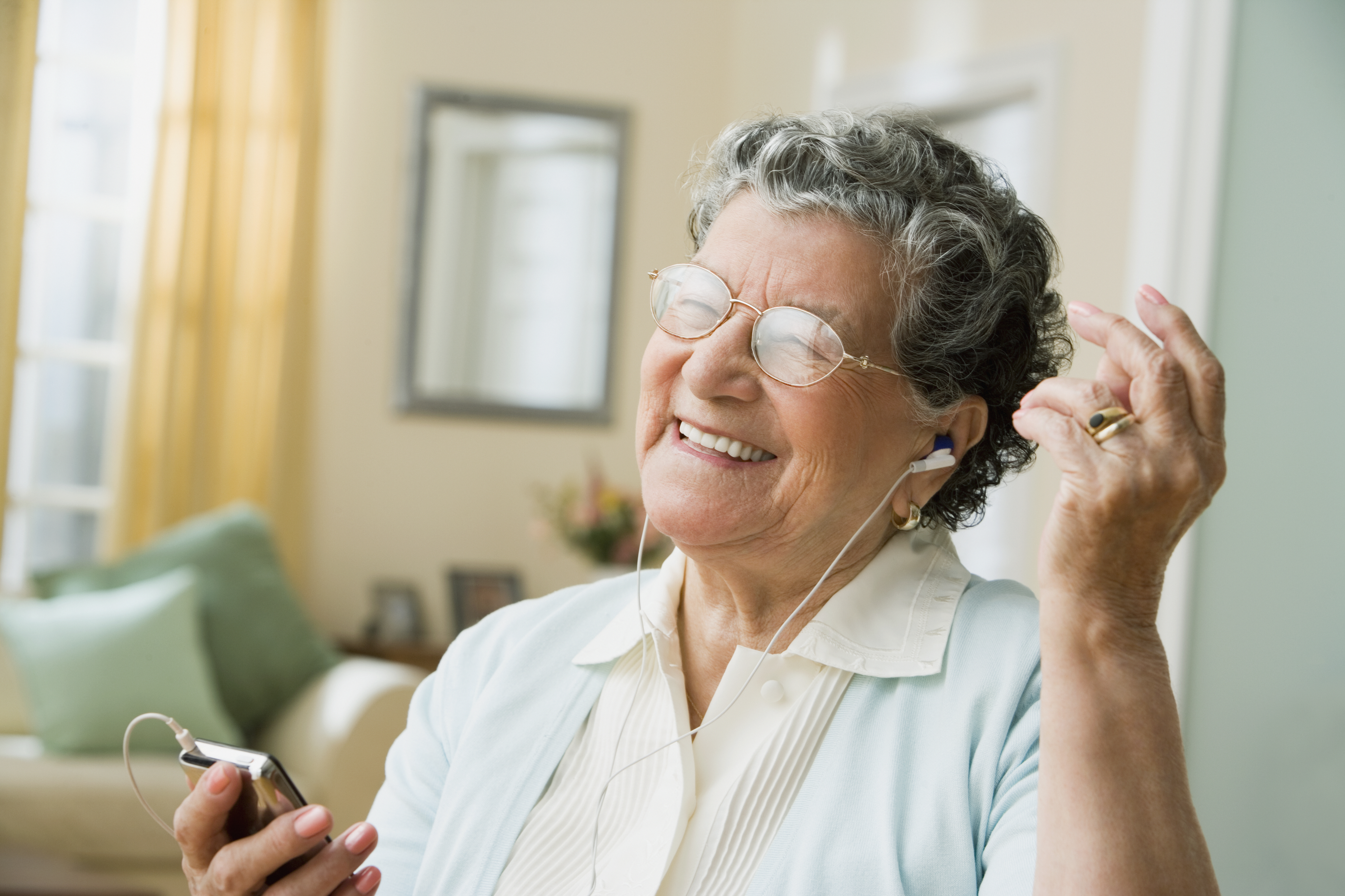 Senior Hispanic woman listening to mp3 player