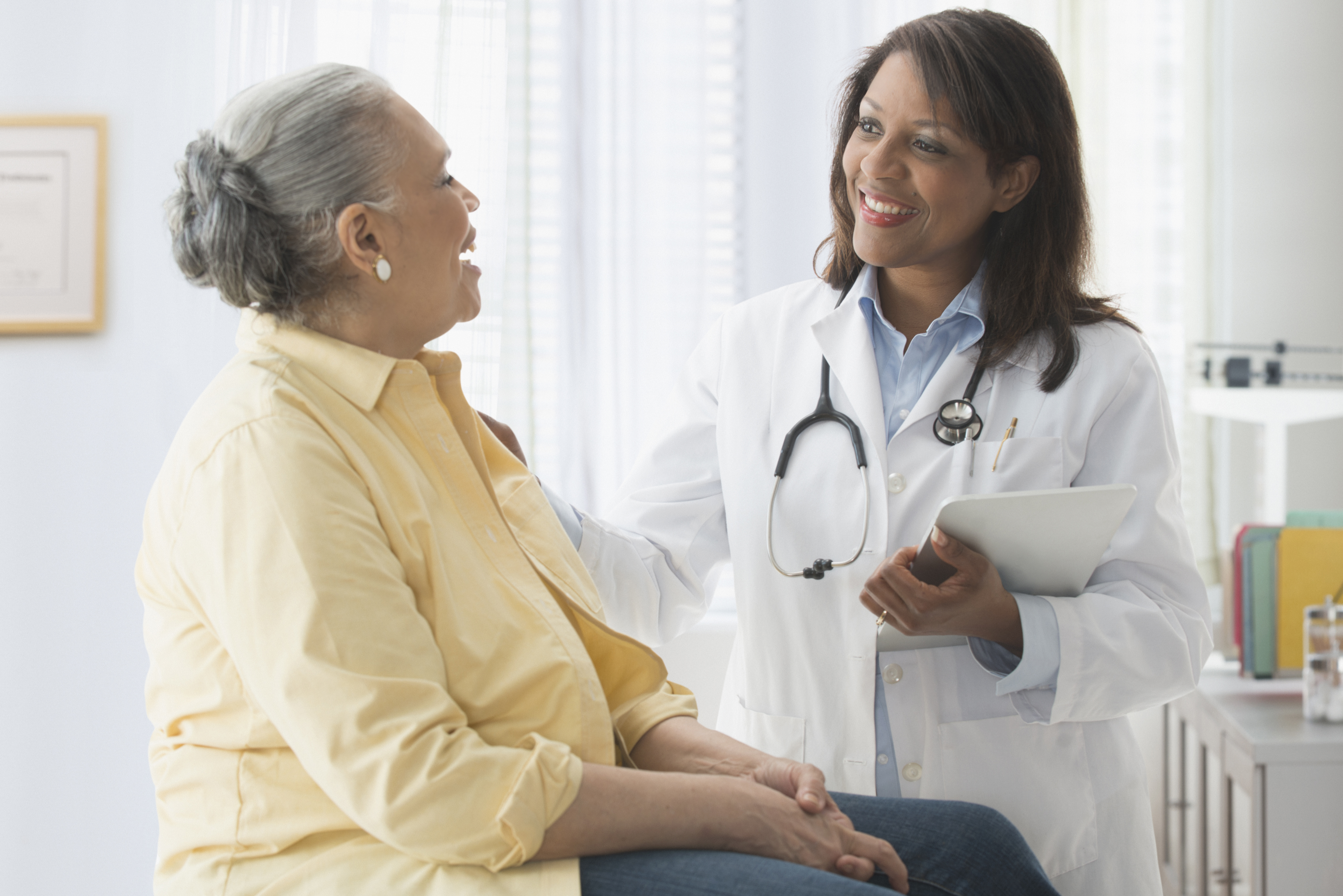 Older woman talking to doctor in office