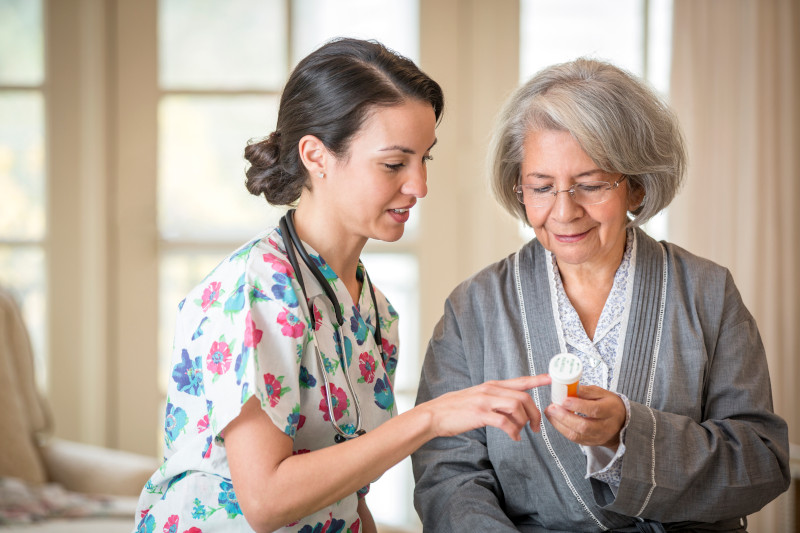 Nurse explaining medication to patient in home