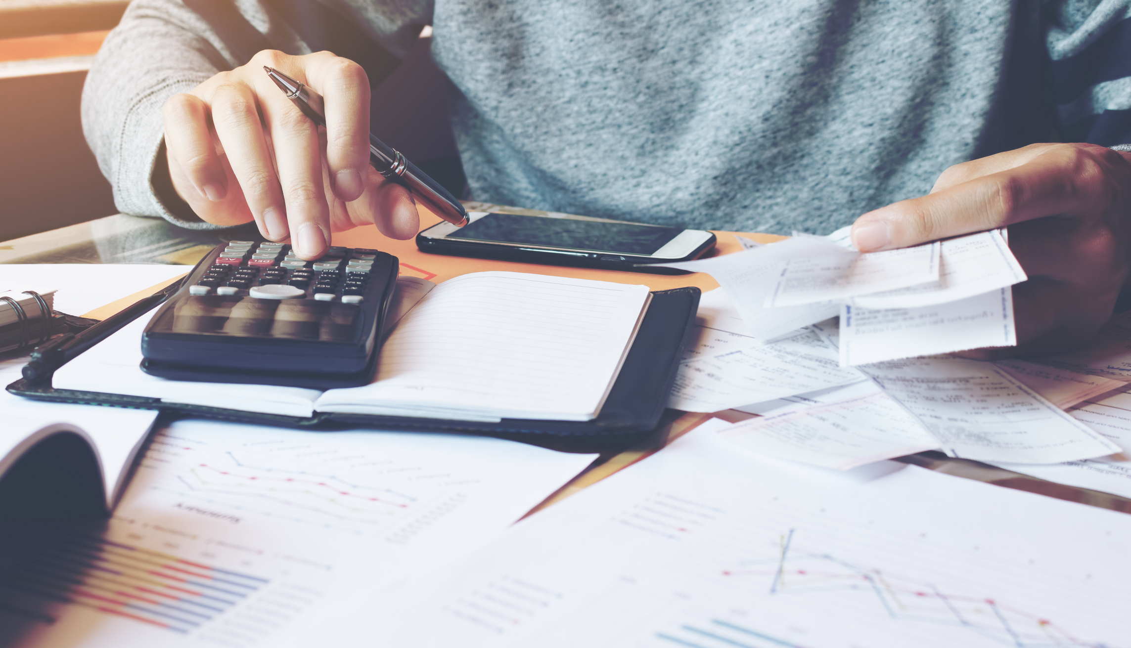 Man using calculator and calculate bills in home office.