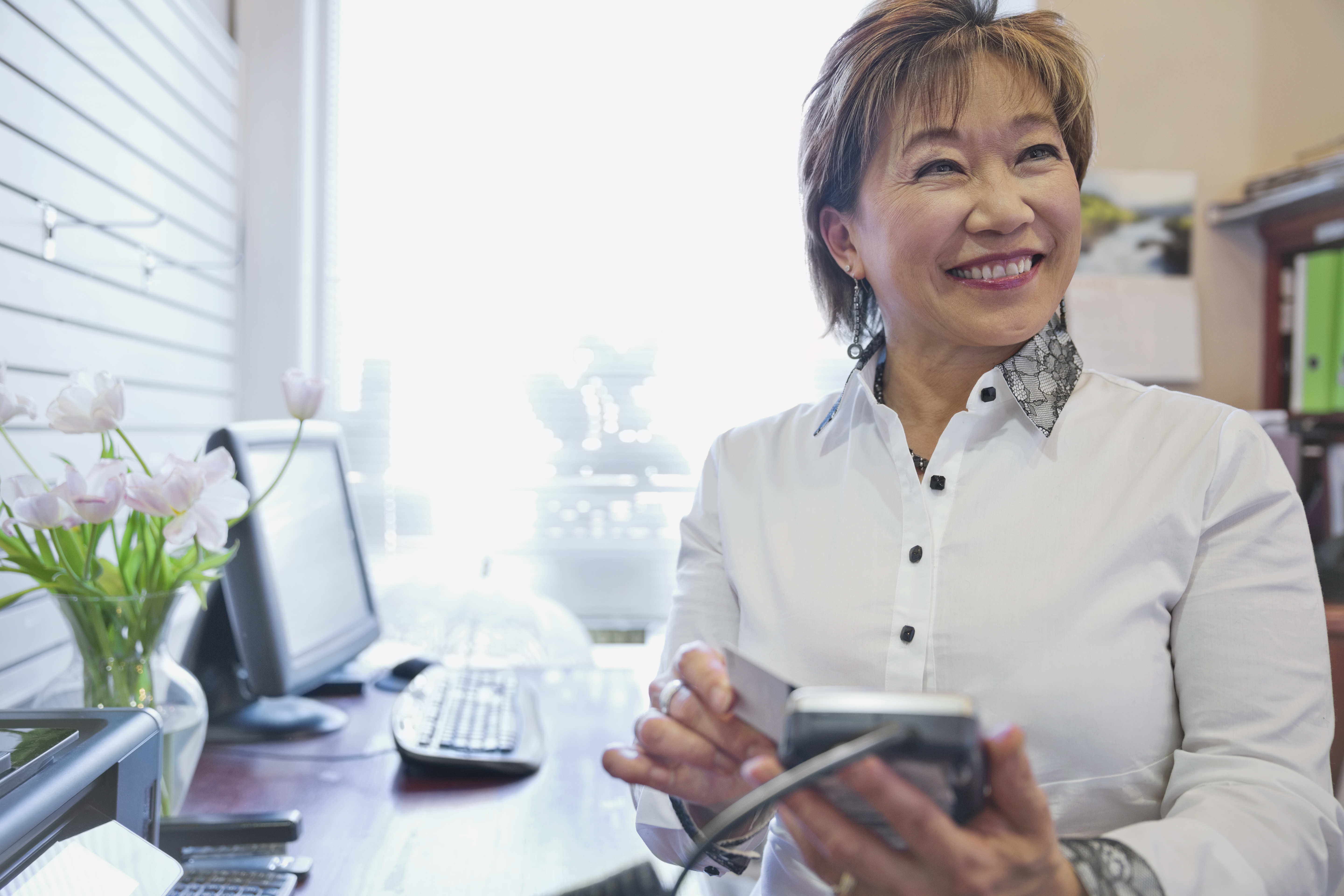 Woman small business owner taking payment in bridal store