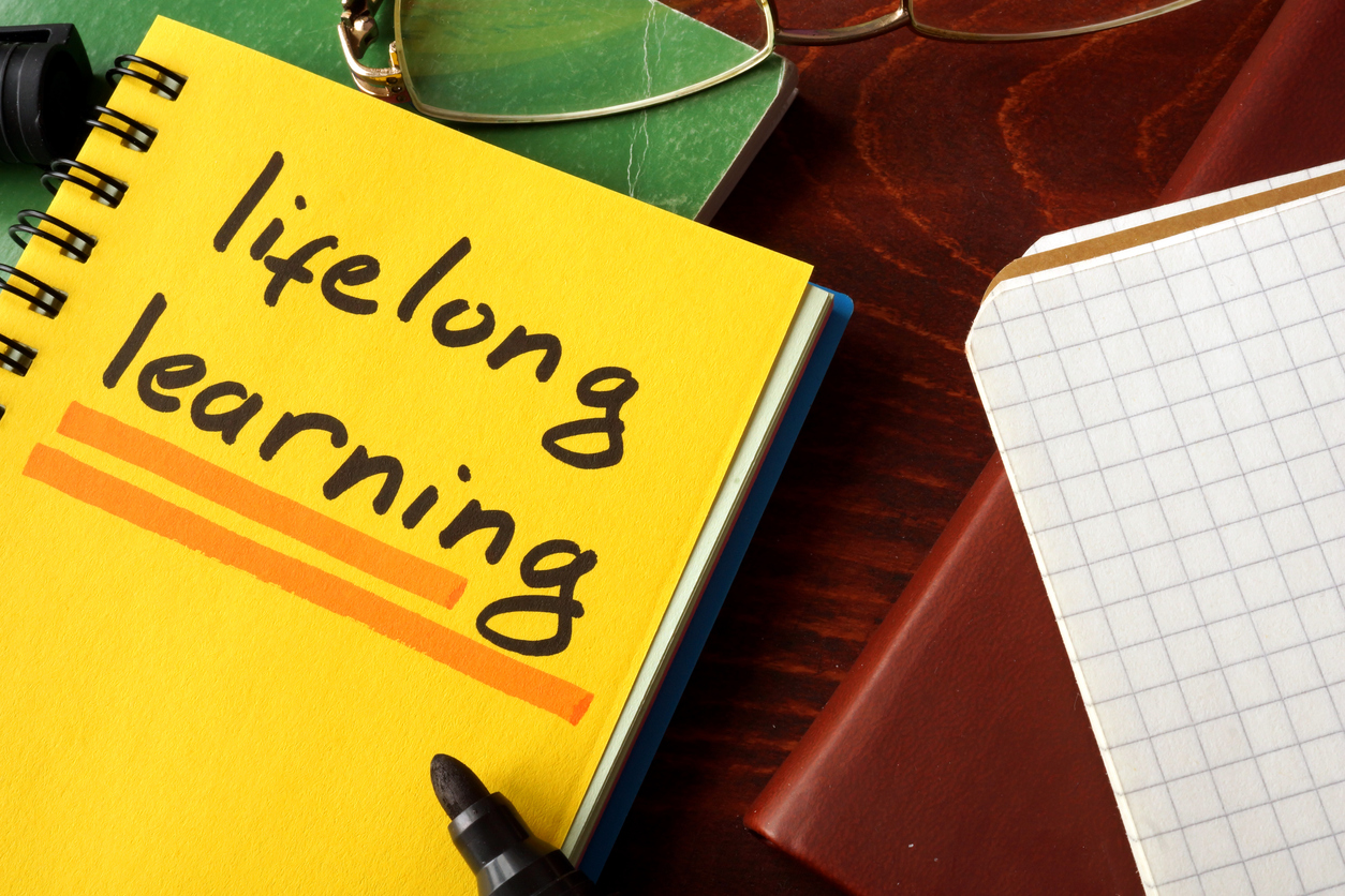 Notebook with lifelong learning  sign on a table.