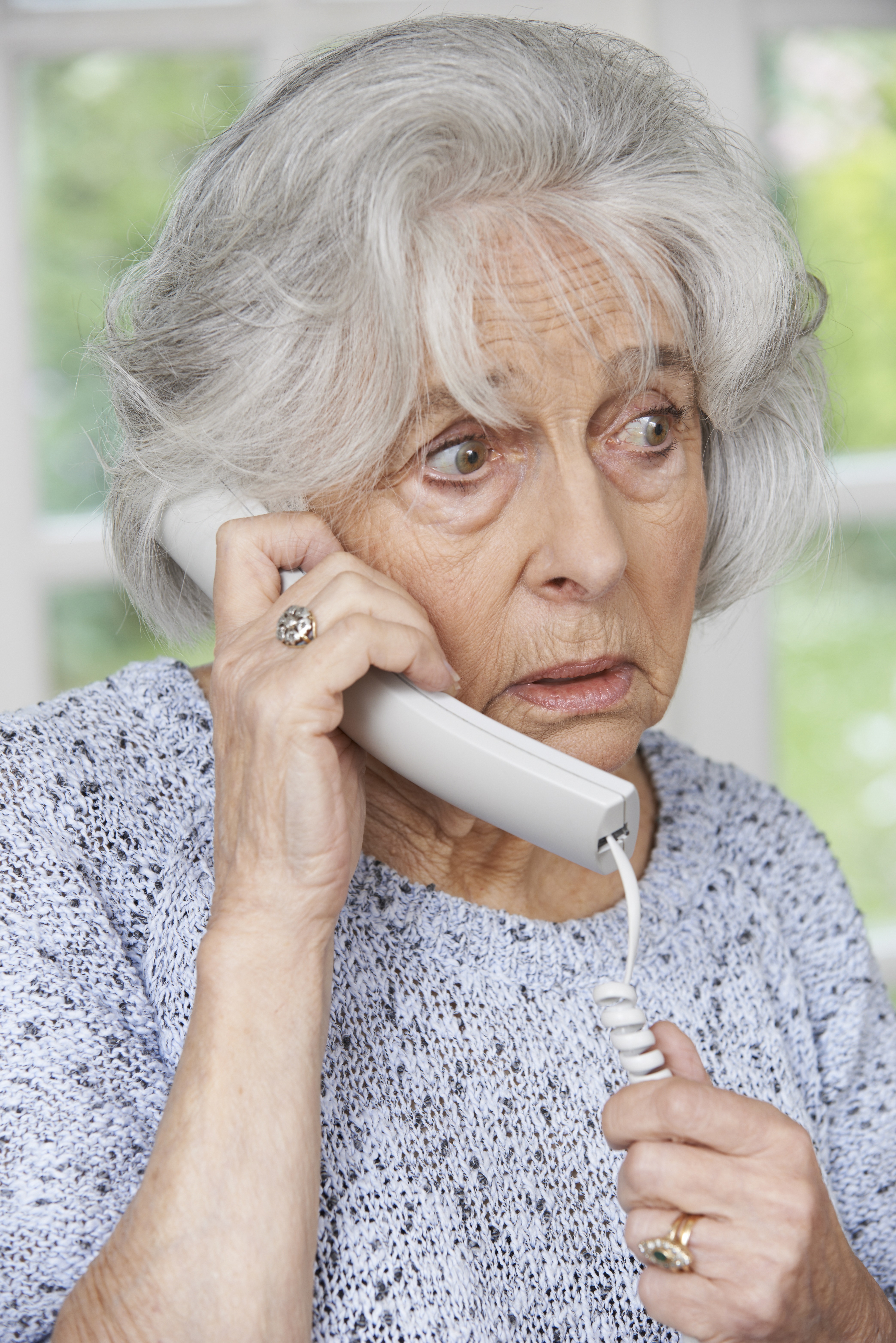 Worried Senior Woman Answering Telephone At Home