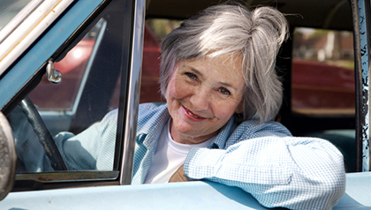 Happy senior out driving the old car