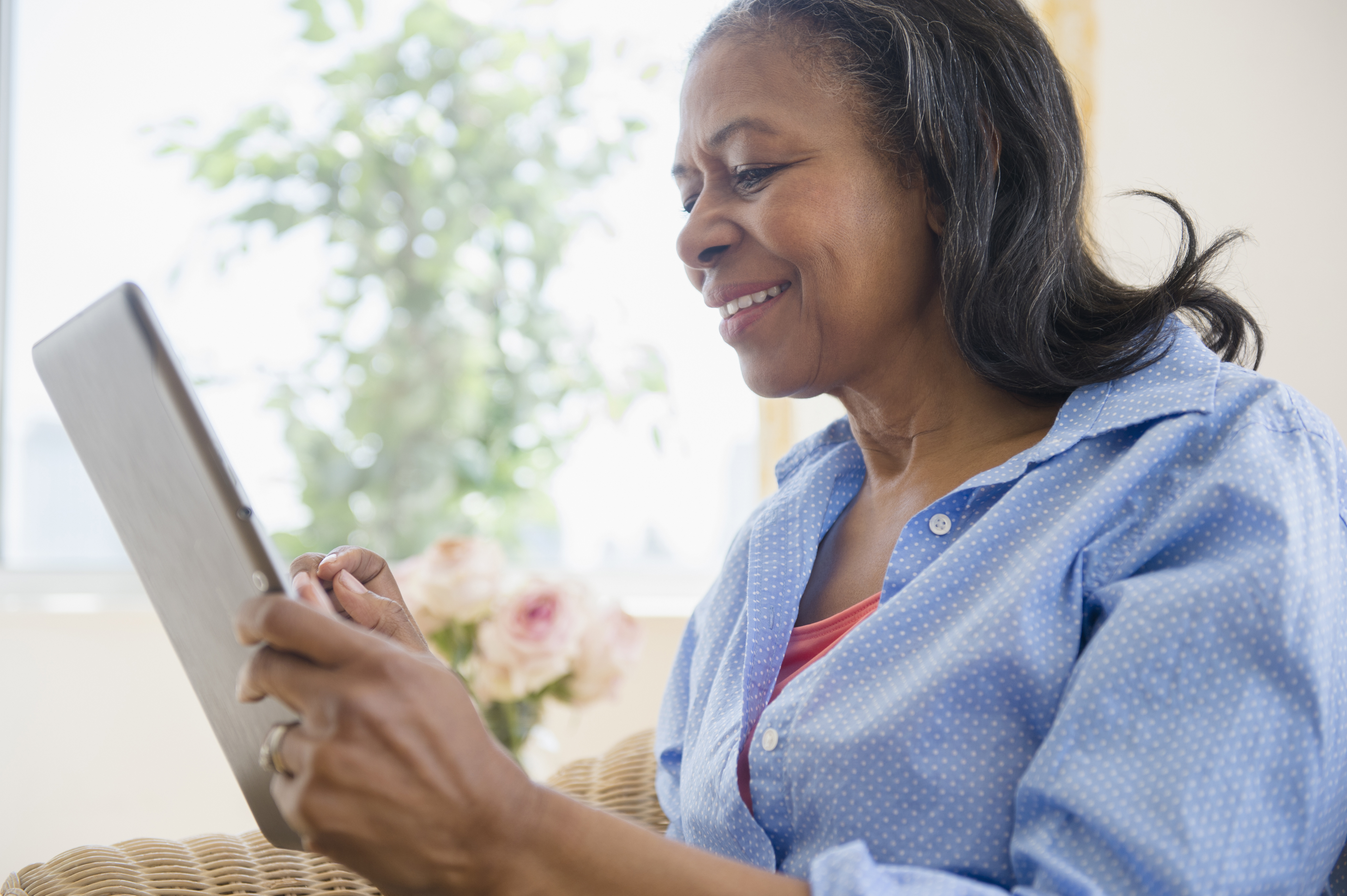 woman using tablet computer on sofa