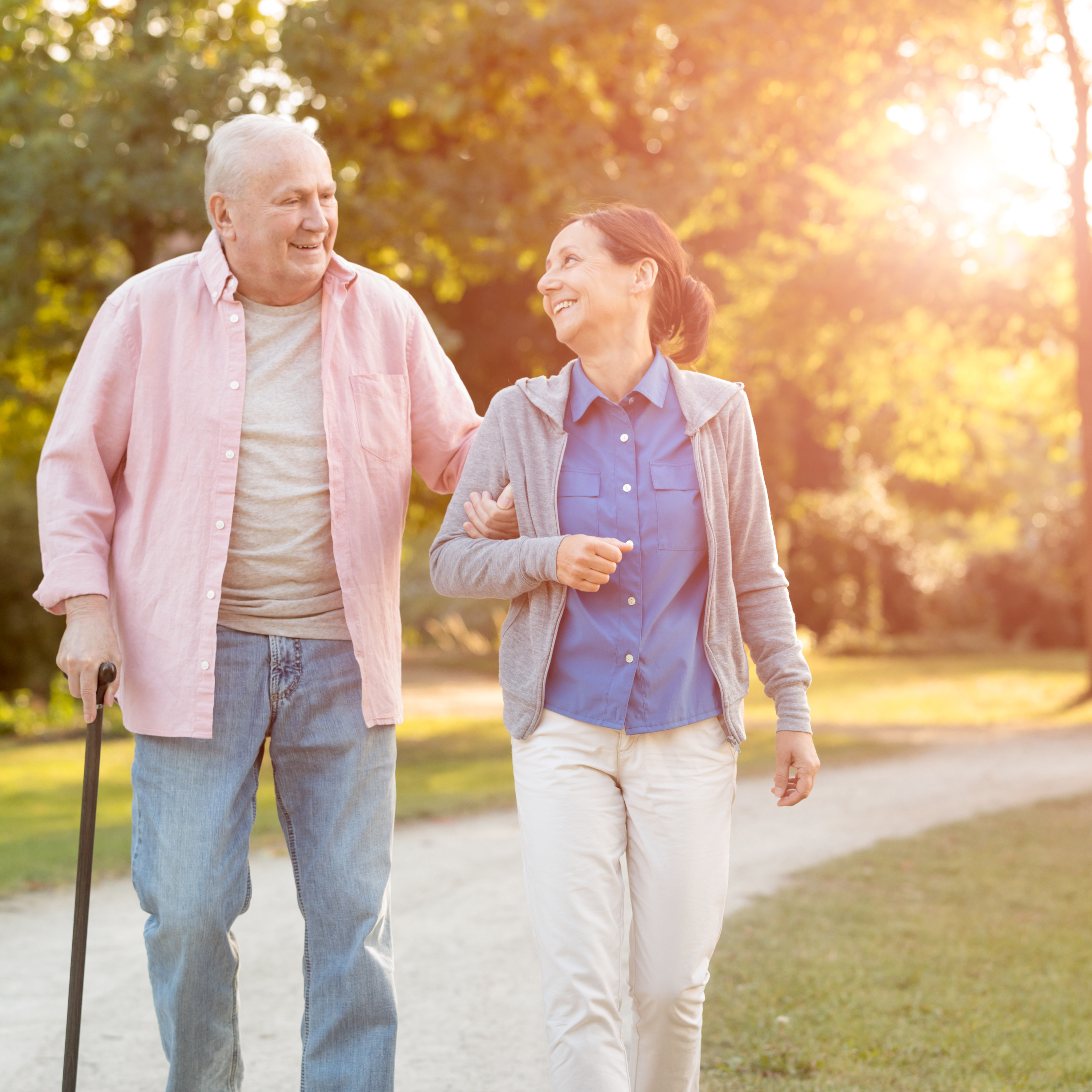 senior woman and caregiver go walking outdoors