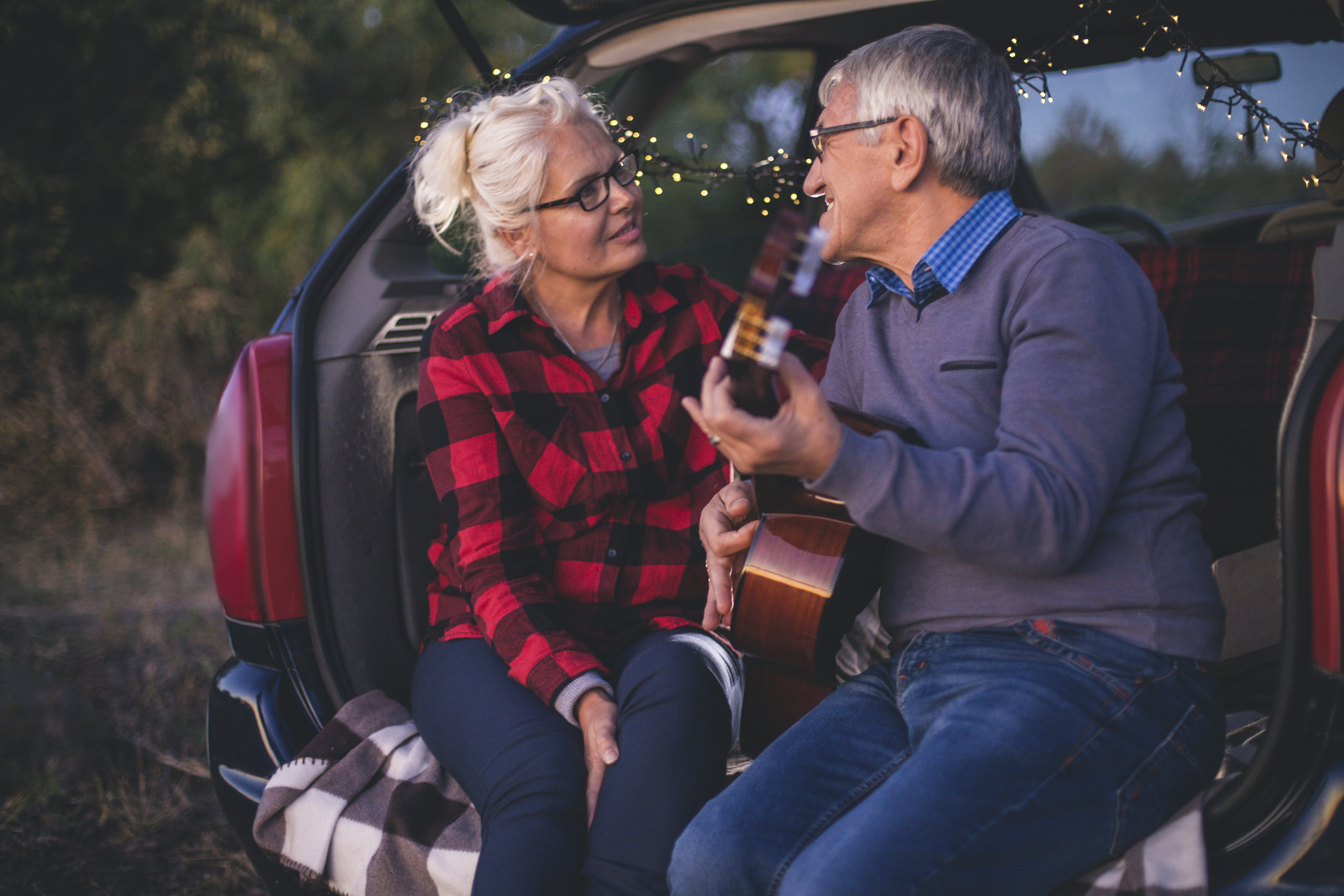 Romantic senior man playing guitar for beautiful senior woman