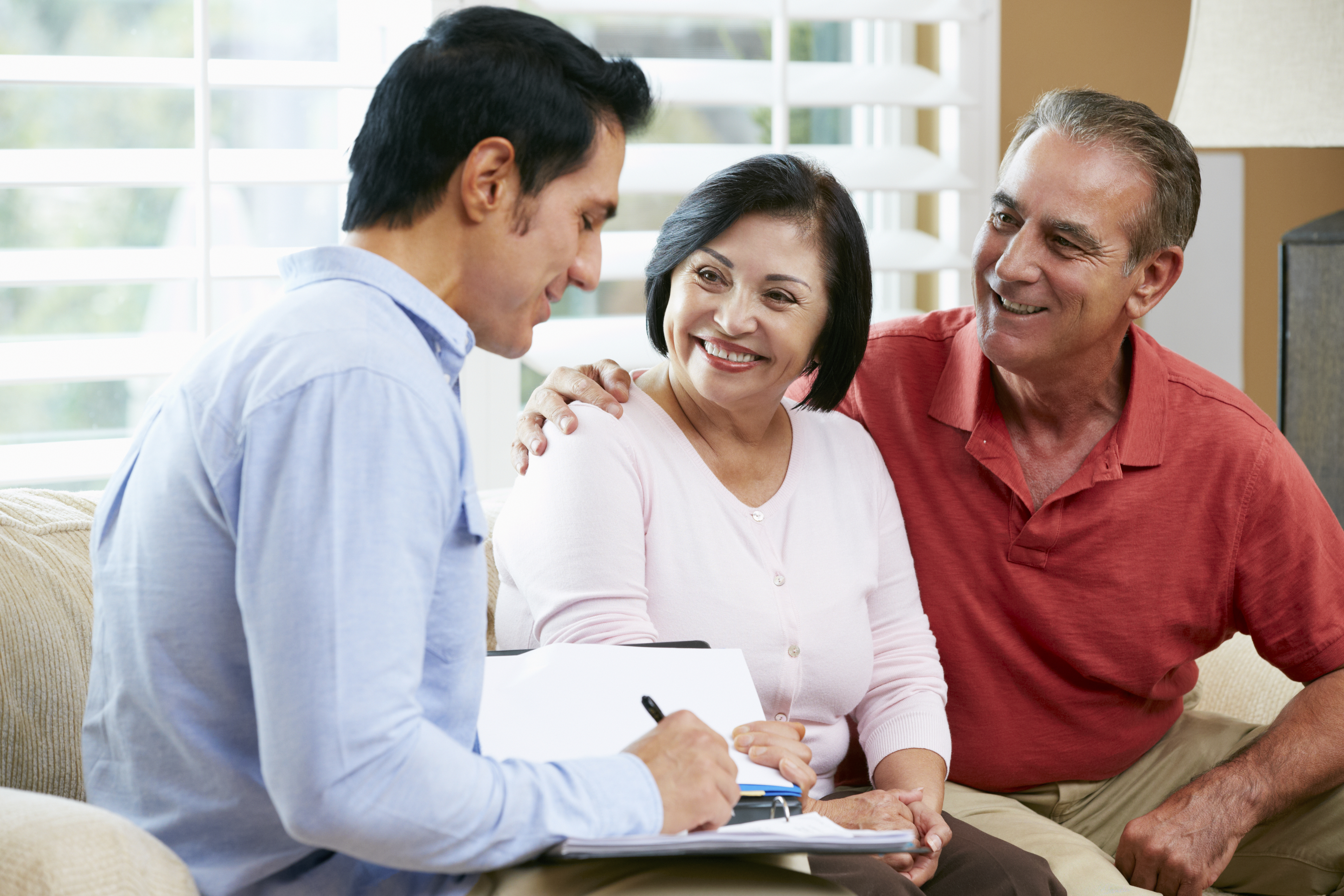 A financial advisor talking to an elderly couple in home