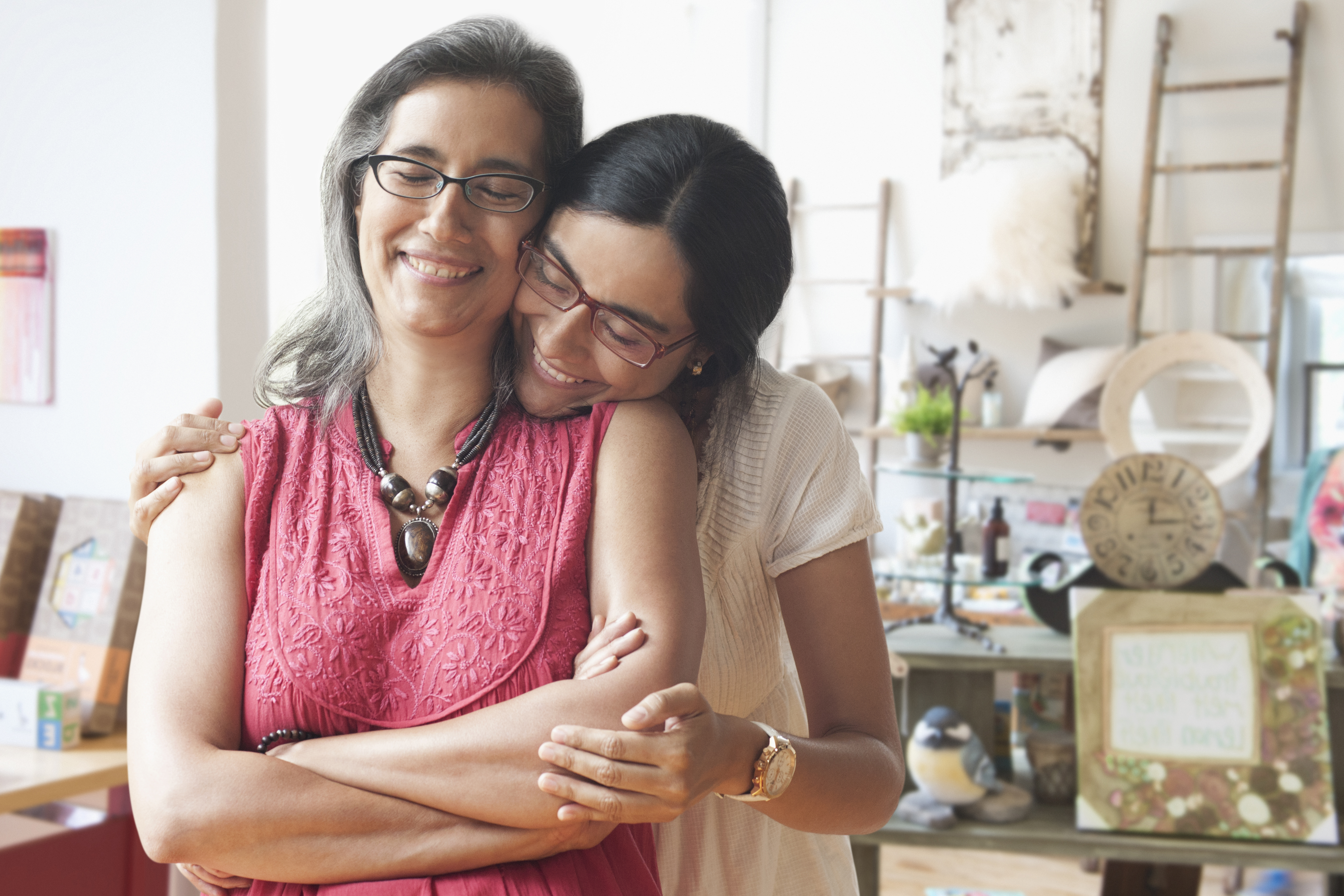 Portrait of smiling daughter hugging store owner mother