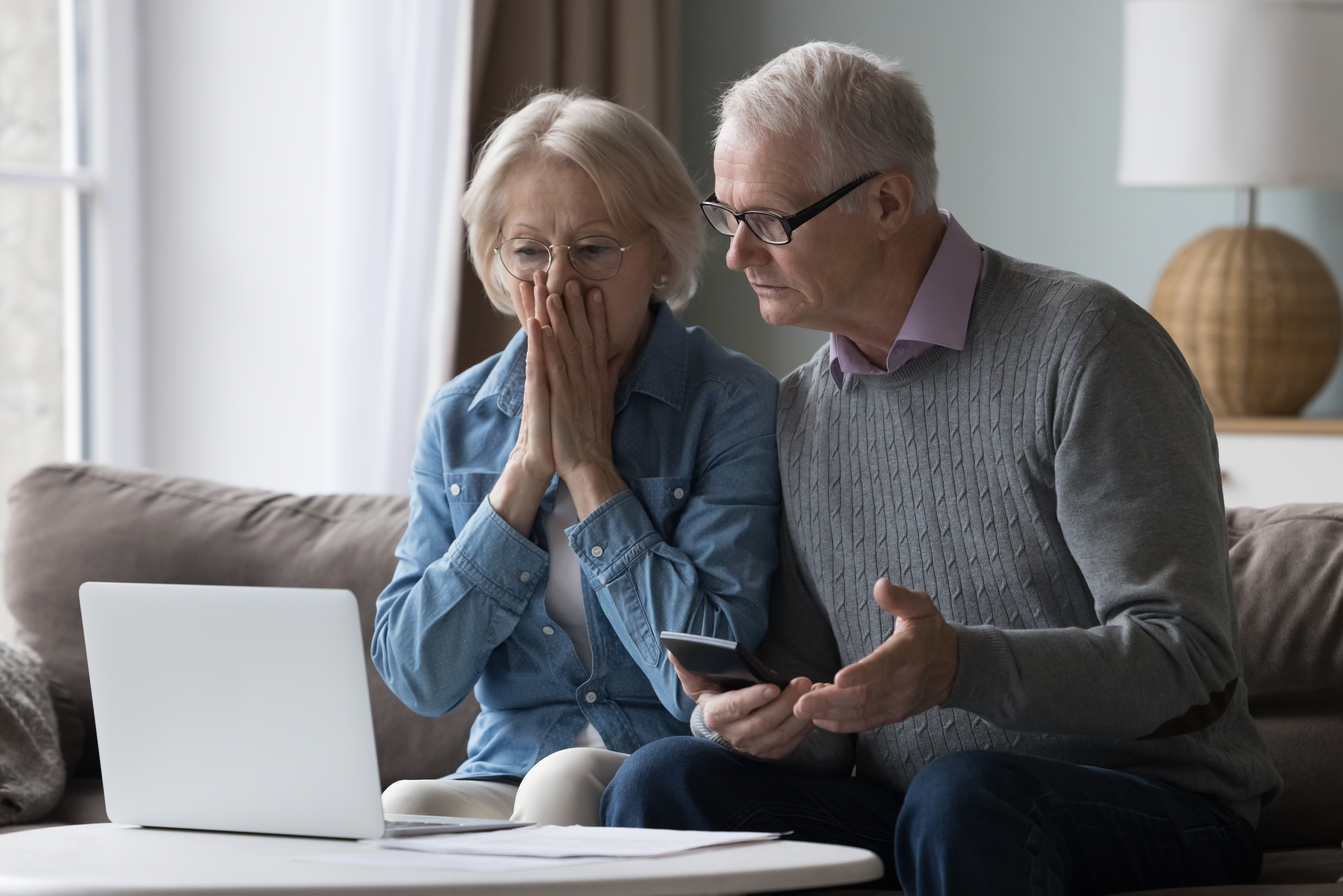 Shocked upset elderly couple getting bad news, finding fraud