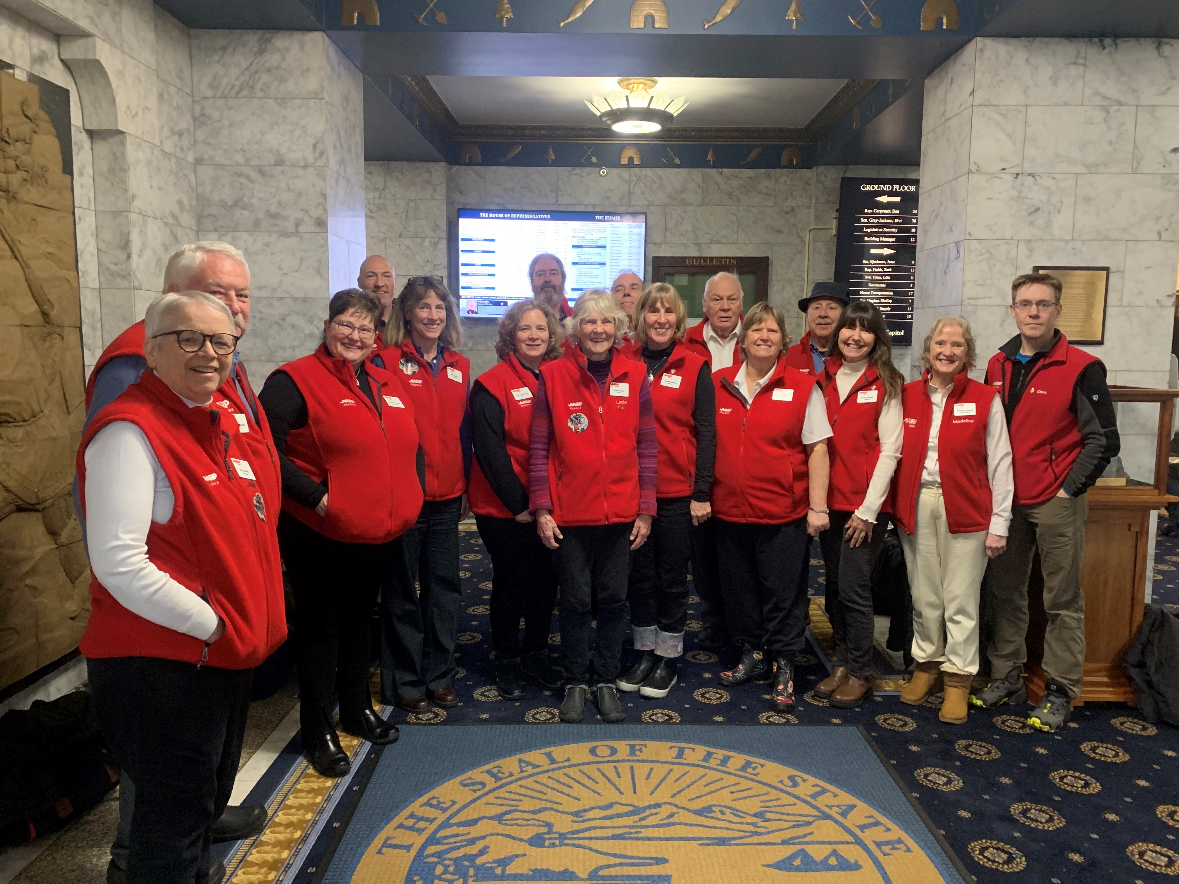 Group of people in red vests in Alaska's Capitol building