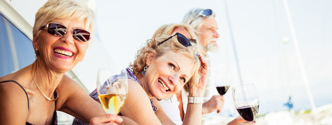 Group of senior friends drinking wine on a yacht