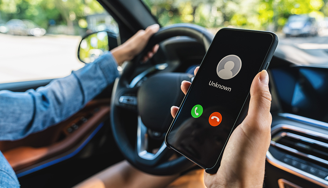 Unknown number calling while car driving. Phone call from stranger. Person holding mobile and smartphone in livingroom late. Unexpected call disturbs at car ride.