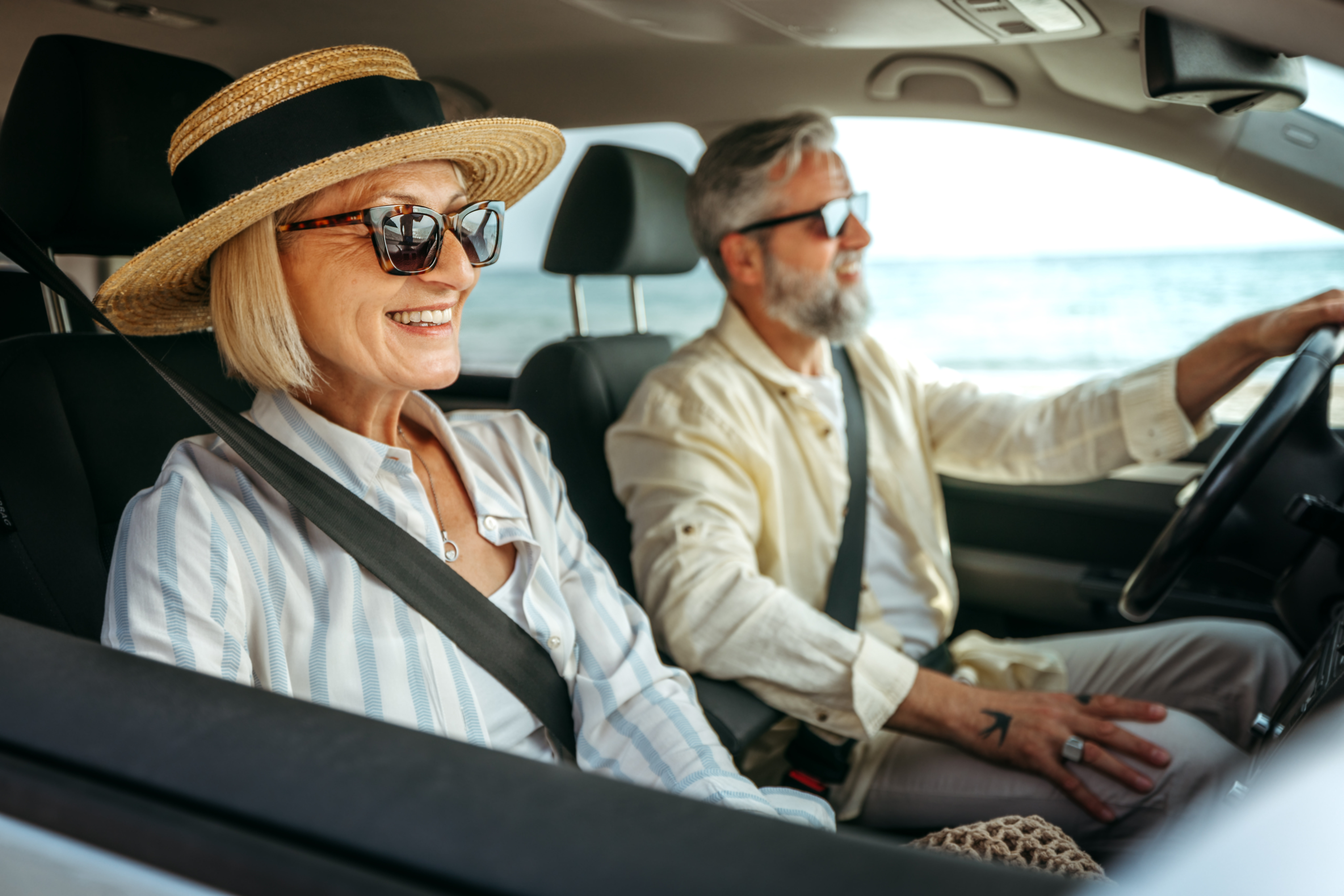 Smiling mature woman enjoying car ride with her husband