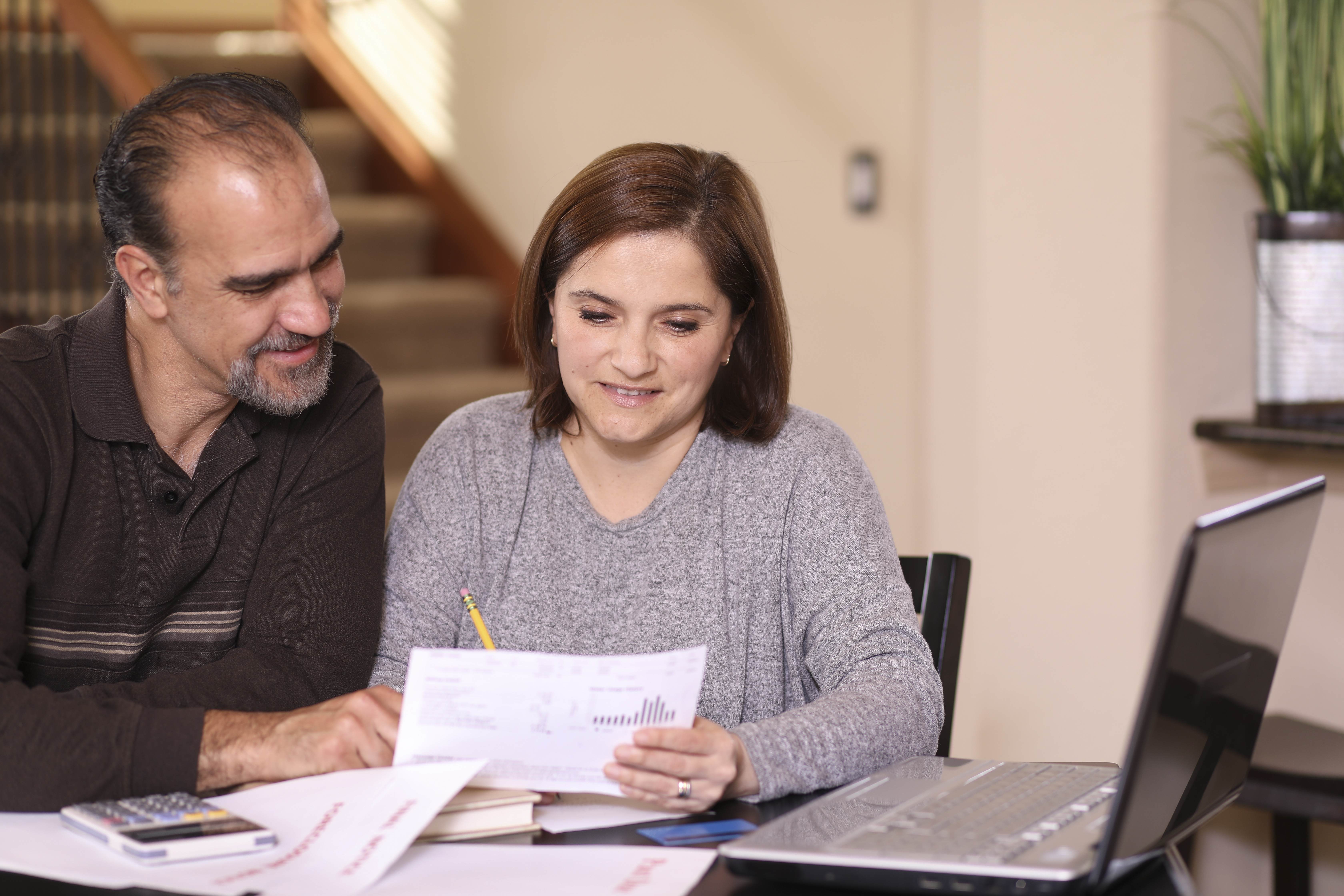 Mature couple working out family finances together at home.