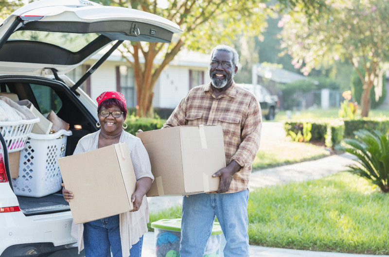 Senior African-American couple moving, unloading boxes