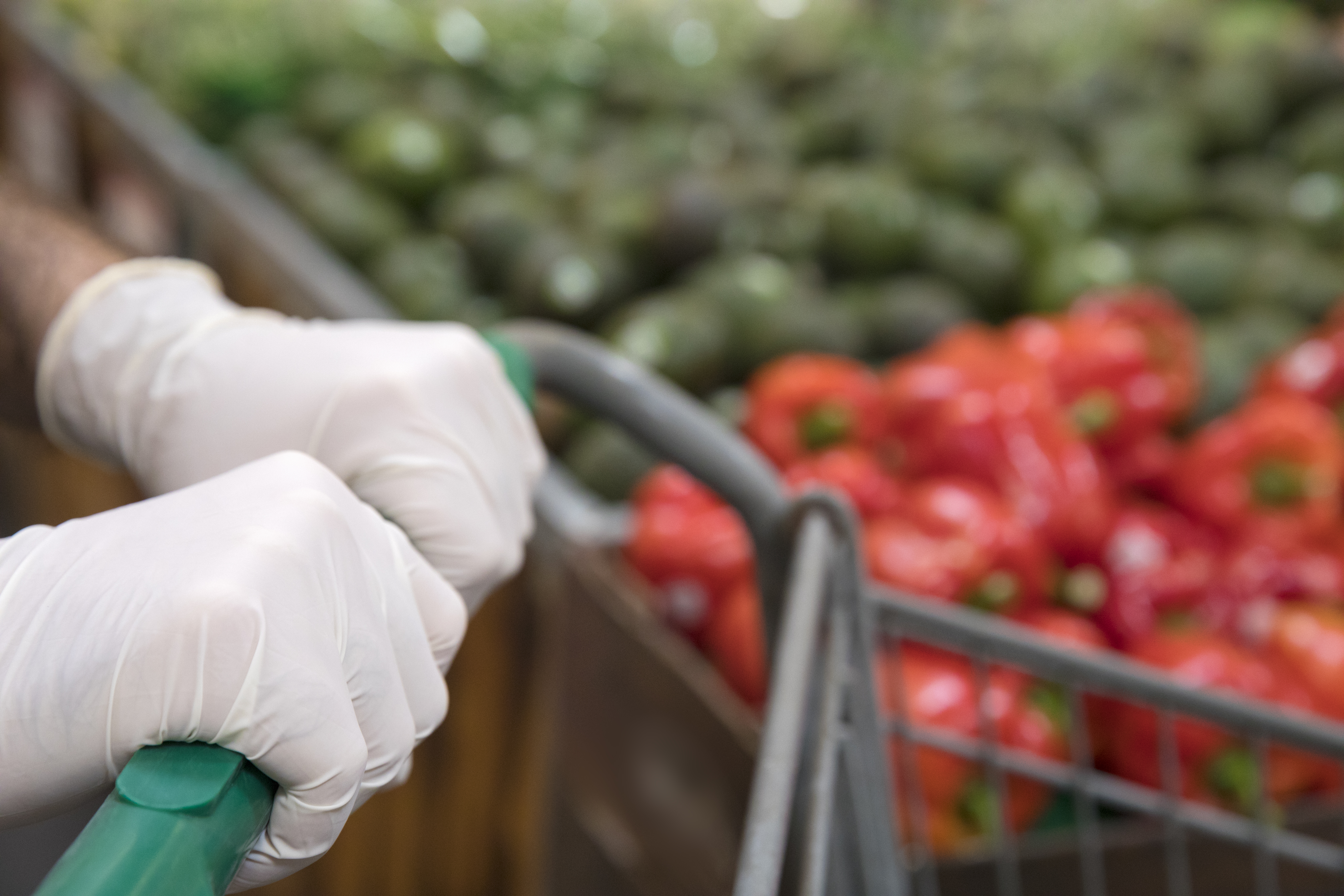 Man wearing protective gloves shopping in the supermarket.