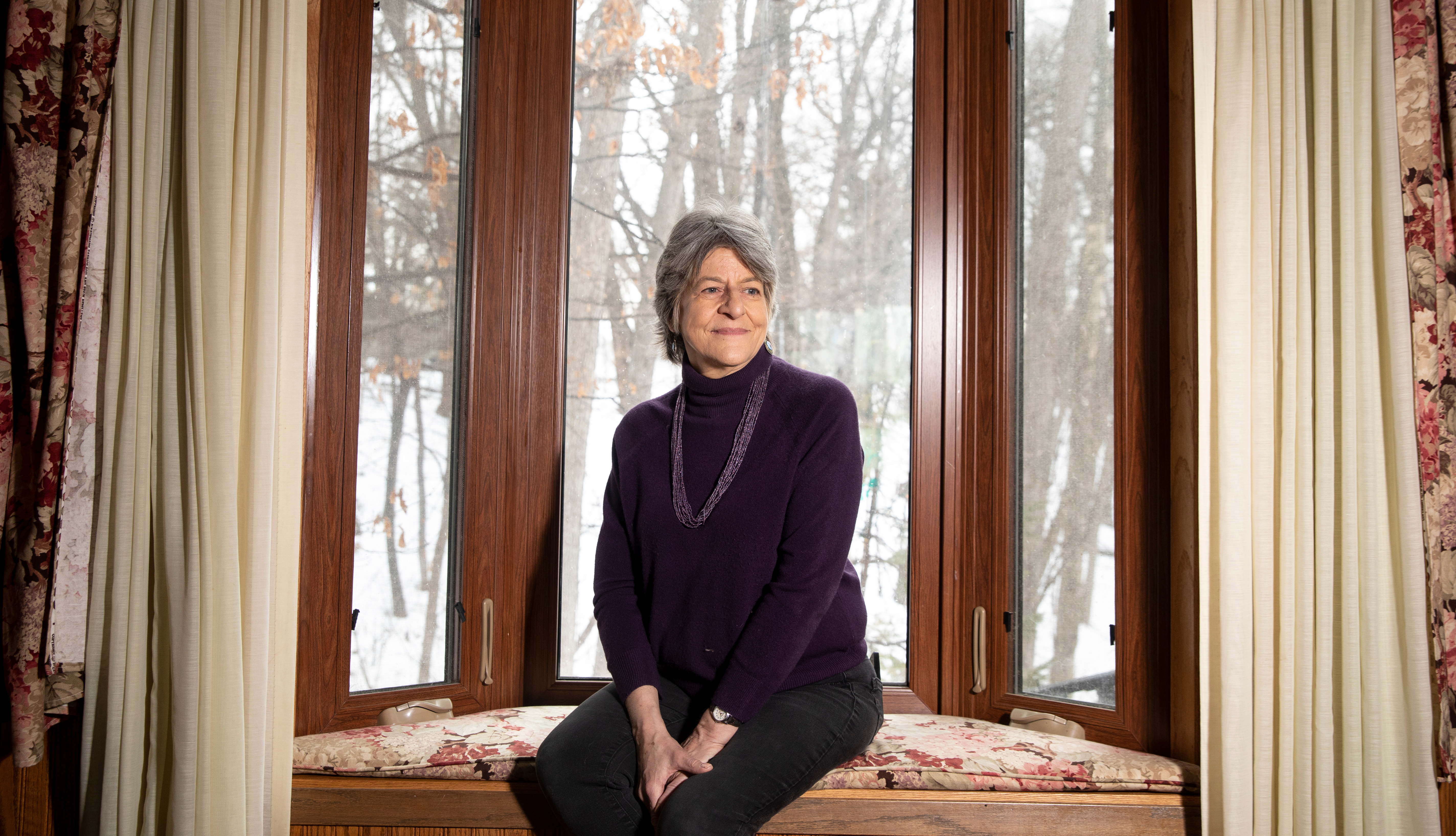 woman sits by window at home