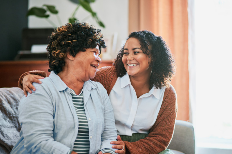 Shot of an elderly woman relaxing with her daughter on the sofa at home