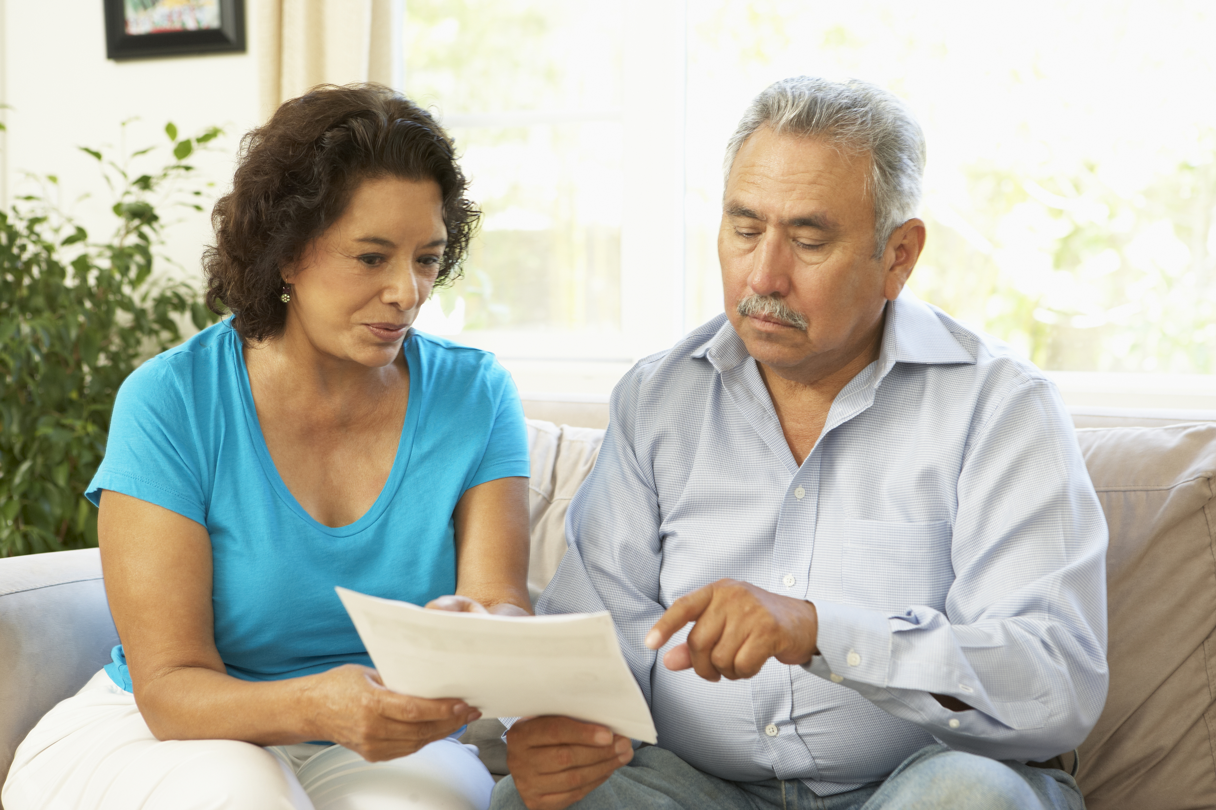 Senior Couple Studying Financial Document At Home