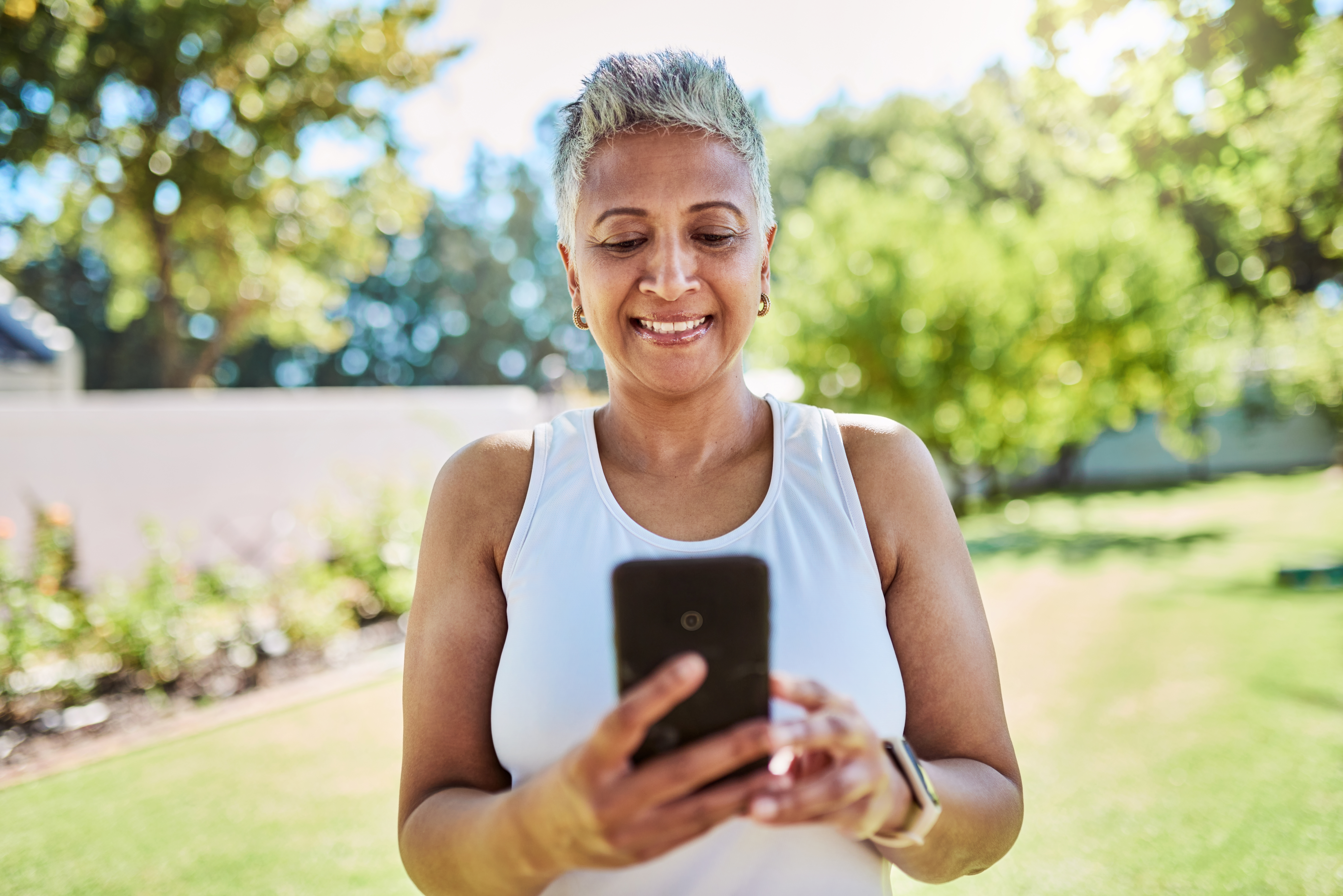 Senior woman, phone and 5g network outdoor in nature park for communication, social media and reading message or news app in summer garden. Elderly lady with happy with internet service on smartphone