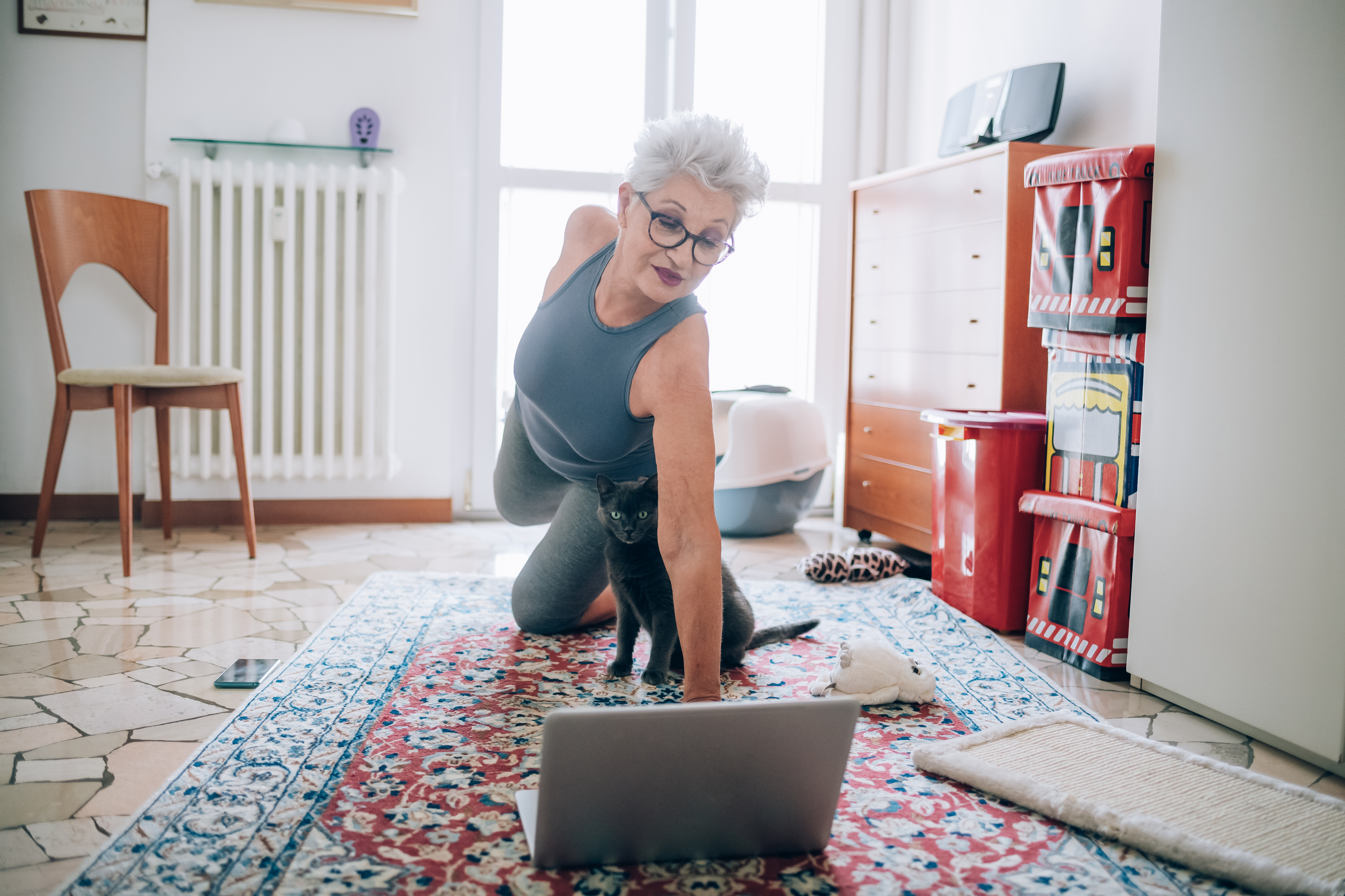 Woman following online yoga class with her cat