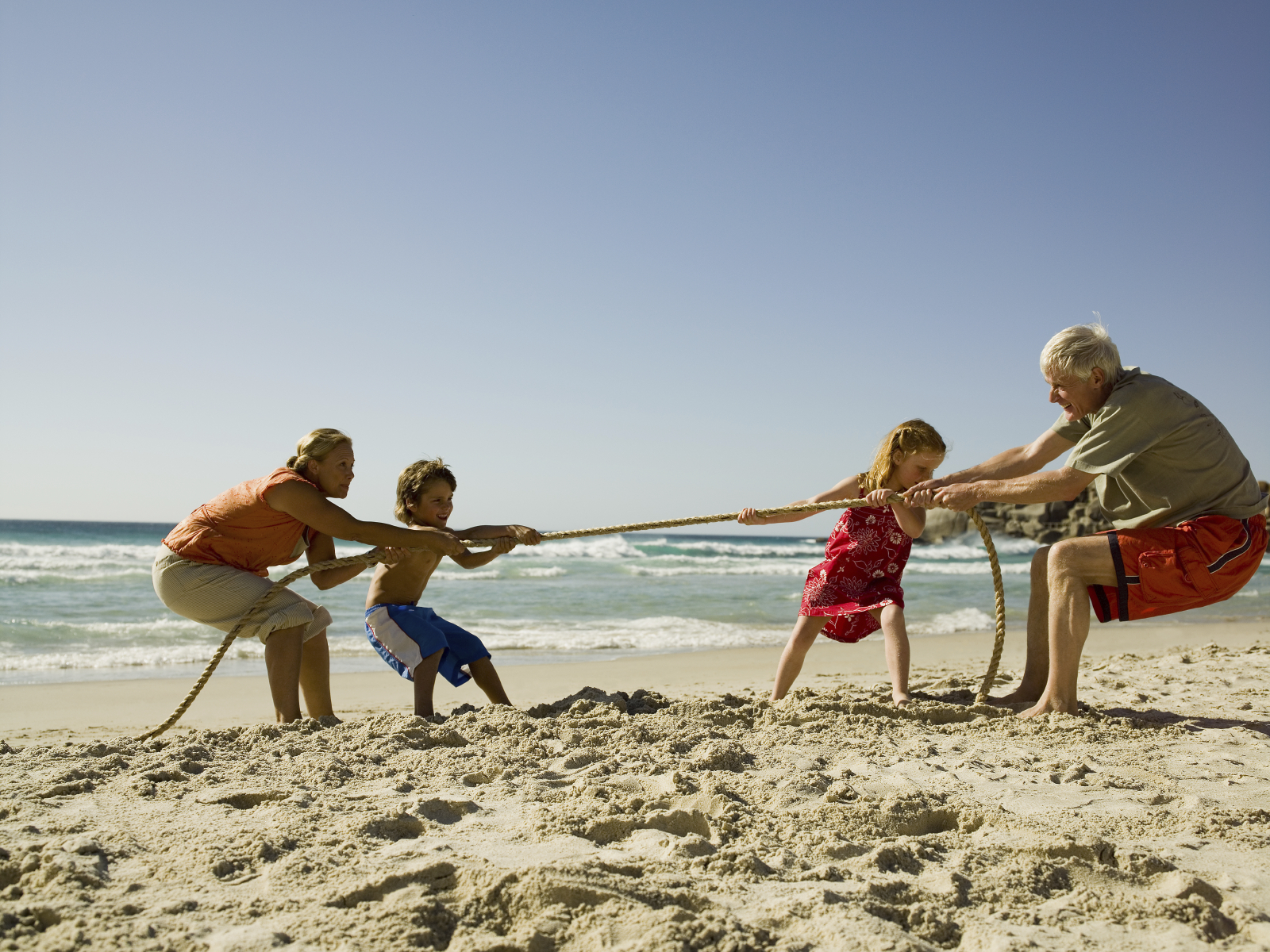 Children and grandparents playing tug of war.