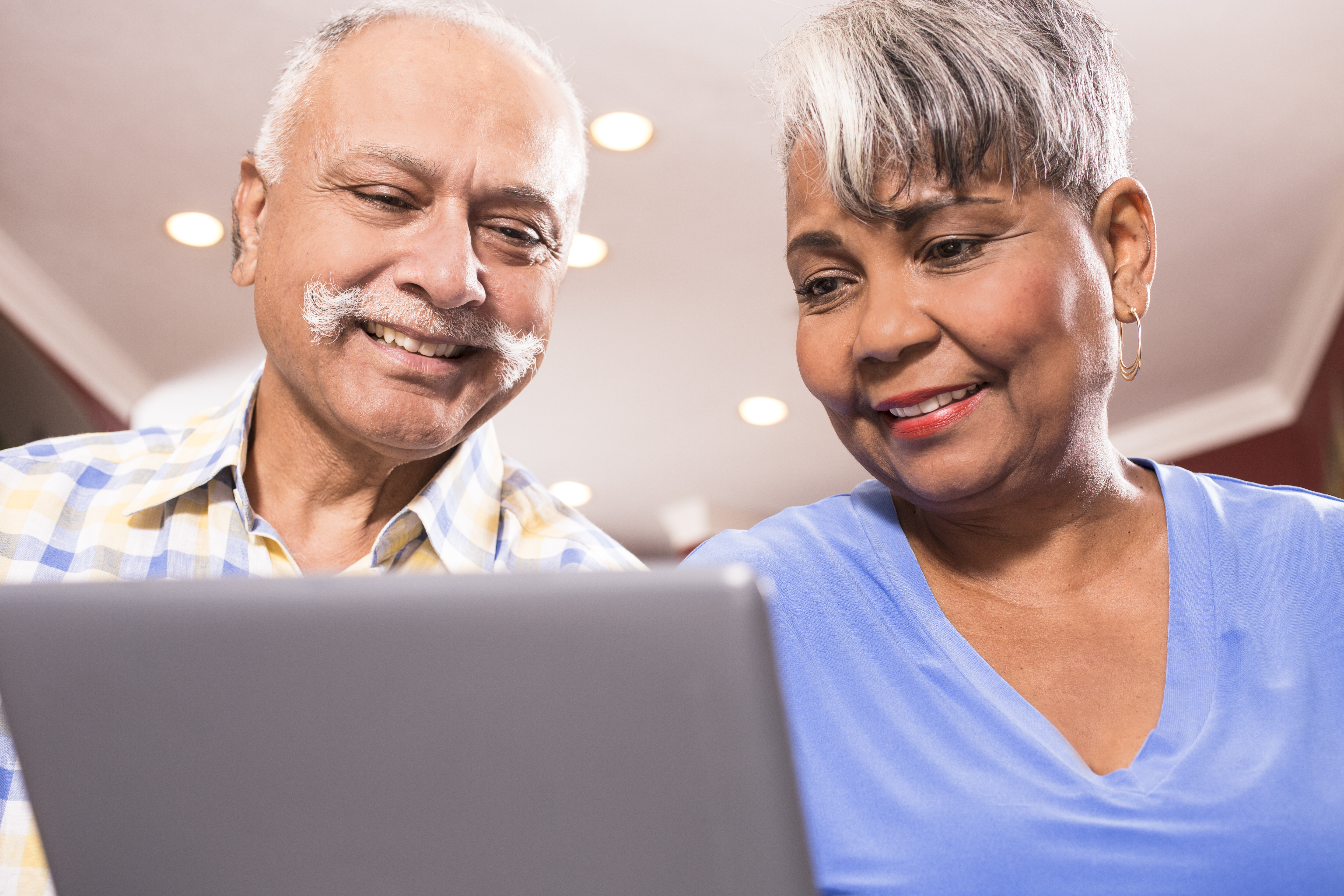 Senior couple using digital tablet computer at home.