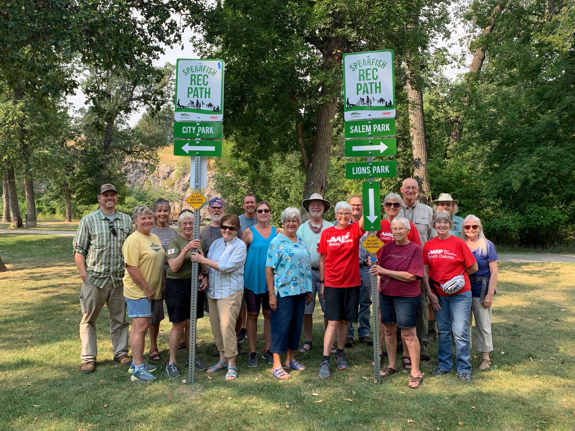 Group of men and women in a park in Spearfish, SD, putting up trail signs