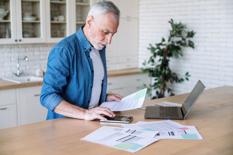 Focused middle aged man making calculations of utility payment