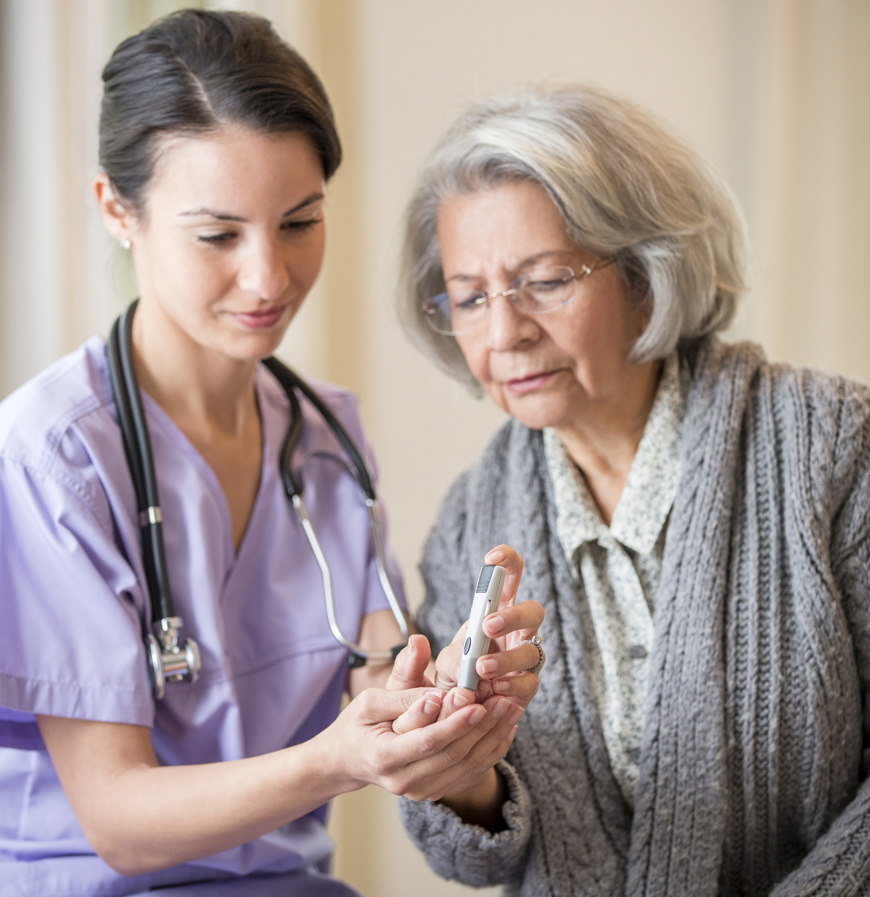 Nurse giving blood sugar test to patient in home