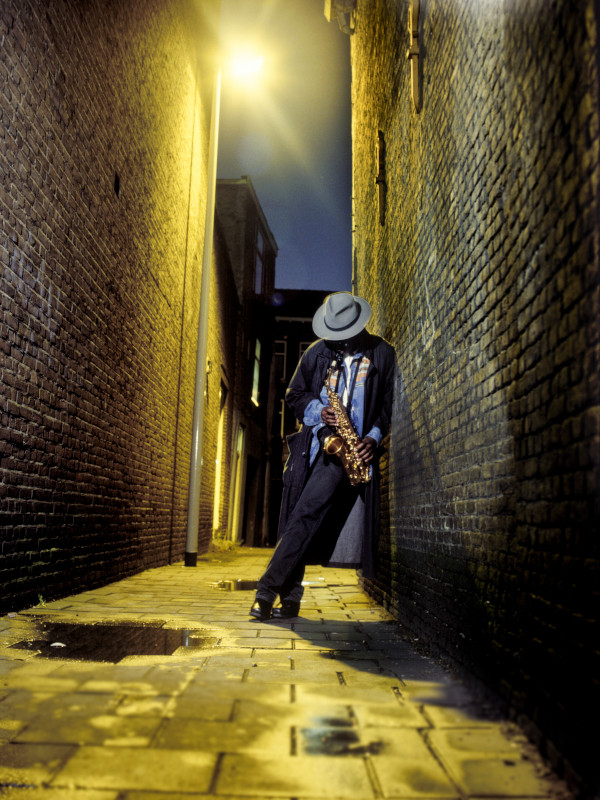 street musician playing saxophone in alley