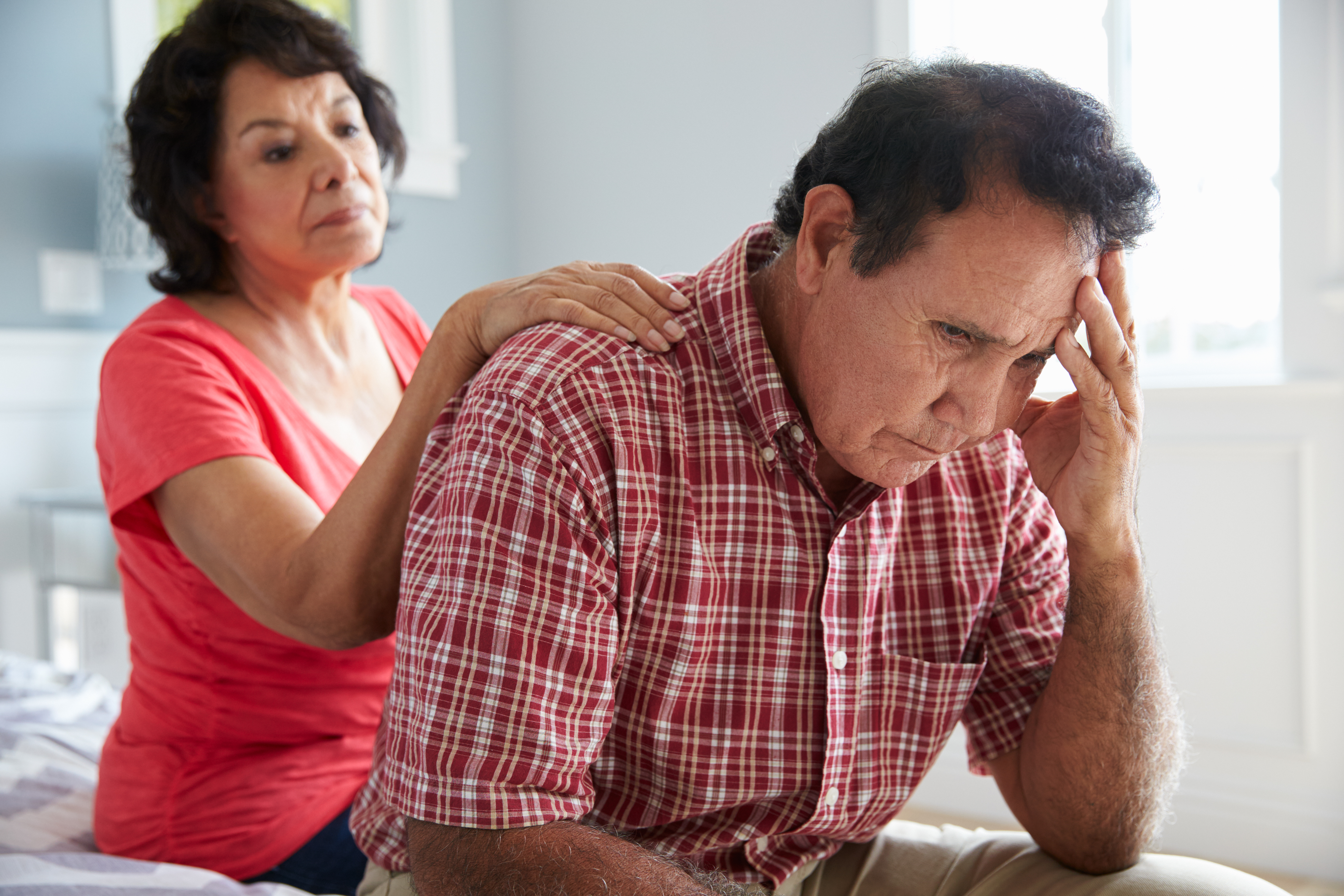 Wife Comforting Senior Husband Suffering With Dementia