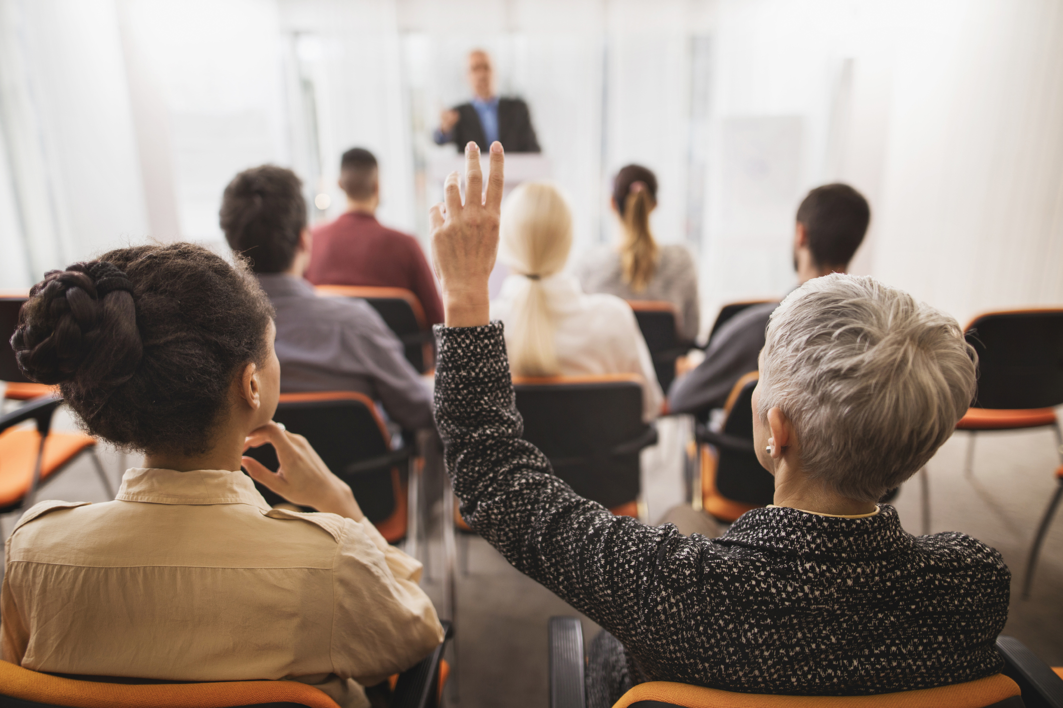 Back view of a businesswoman asking a question on seminar.