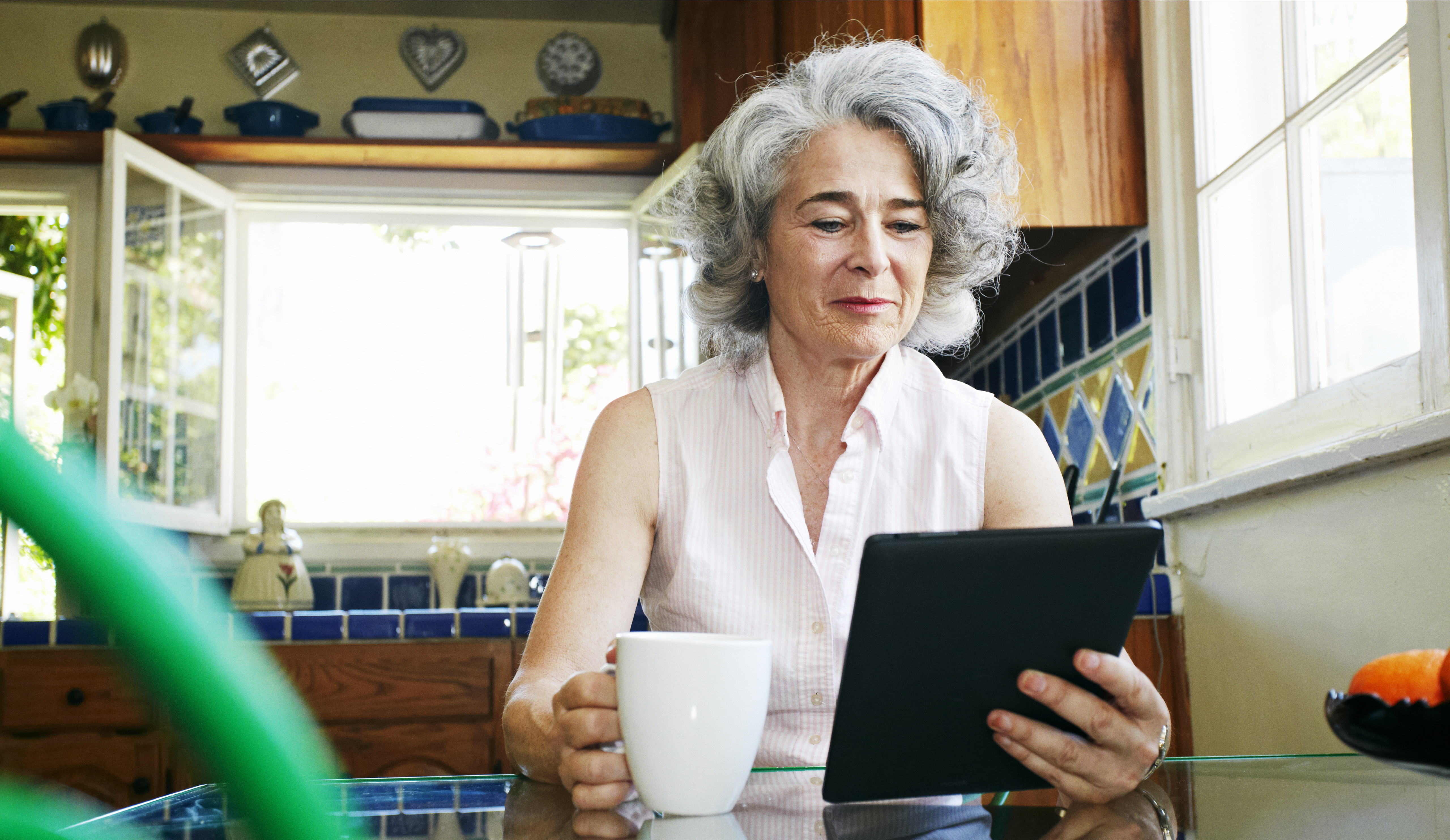 Caucasian woman using digital tablet in kitchen