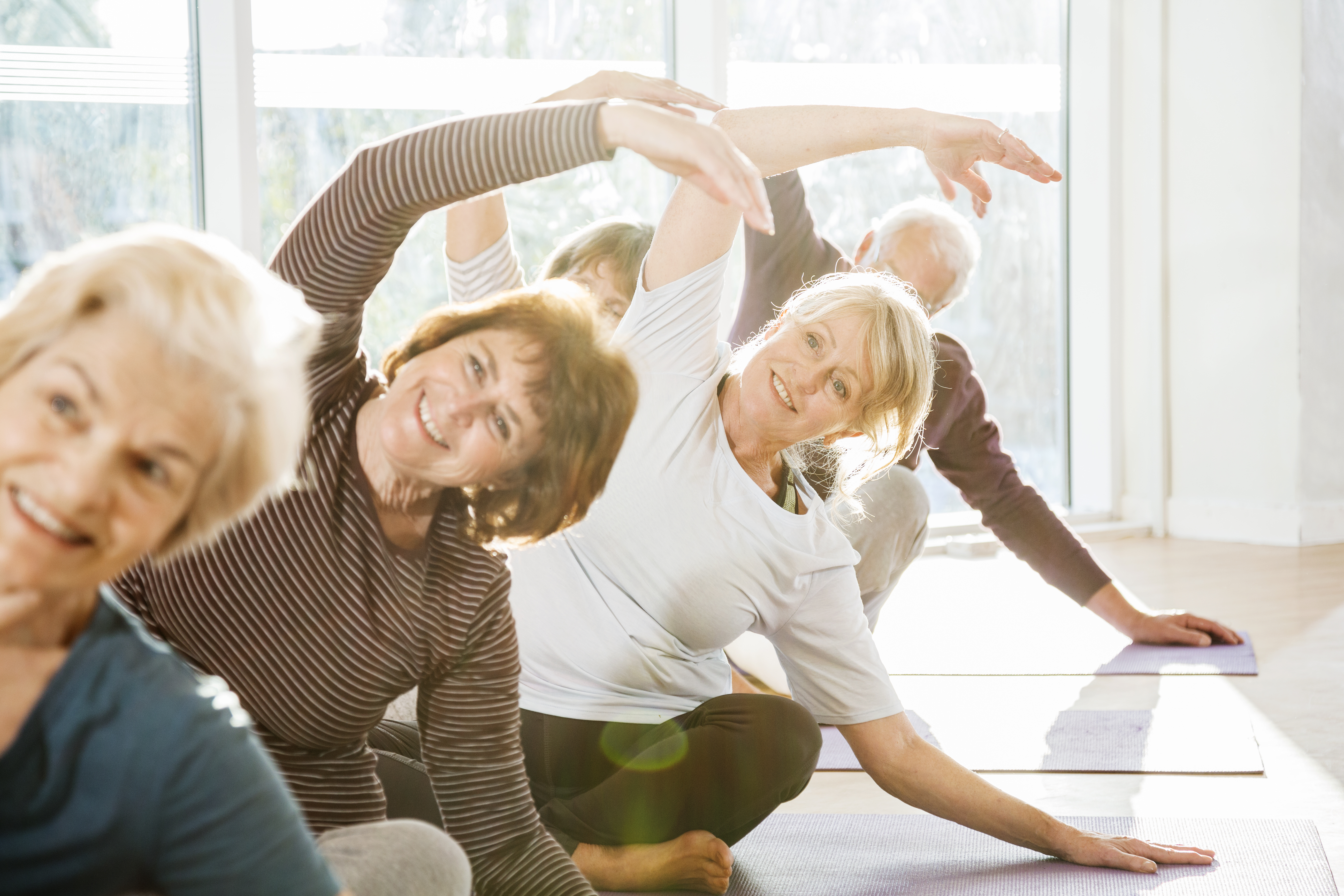 Group of active seniors exercise in yoga class.