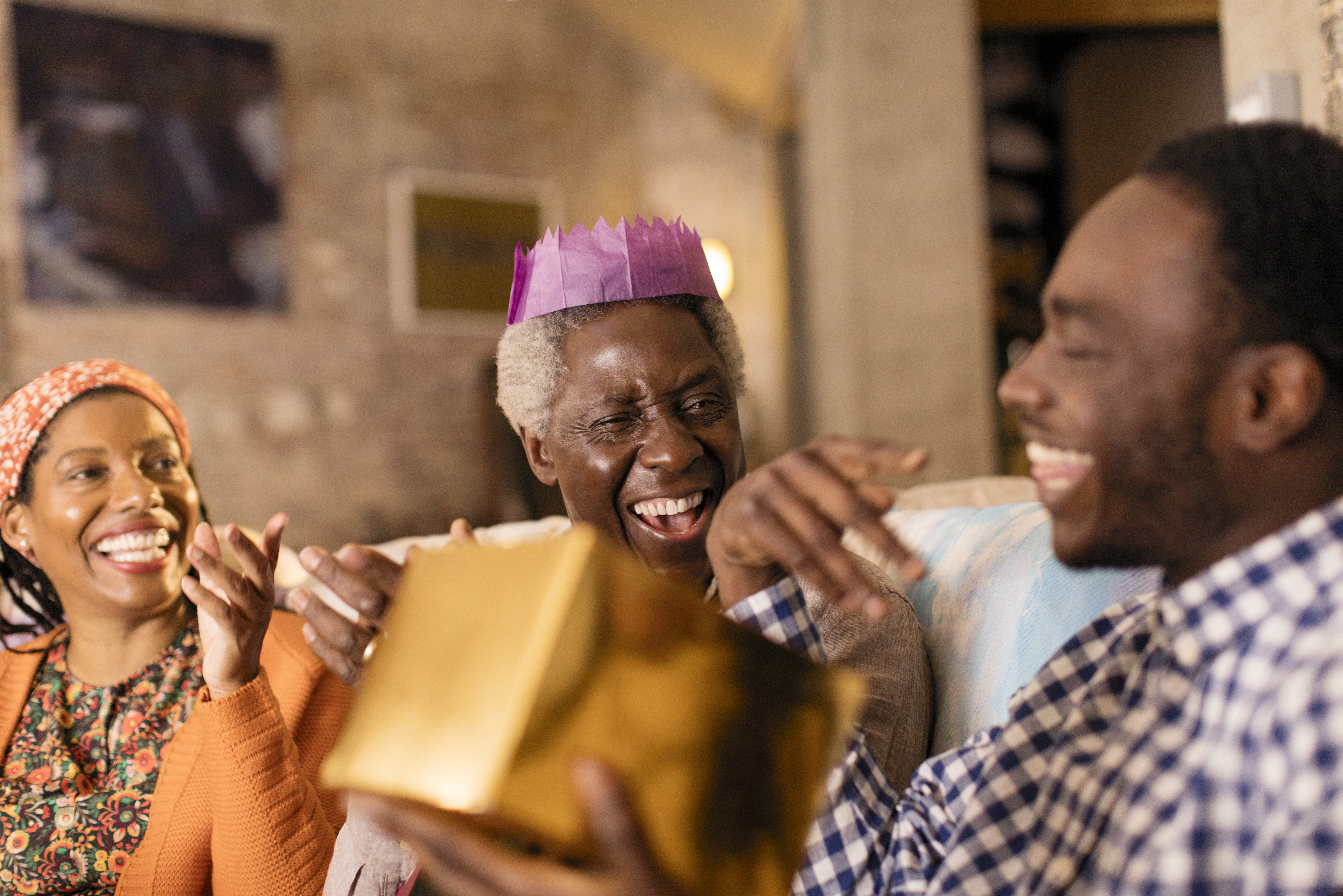 Playful multi-generation family opening Christmas gift