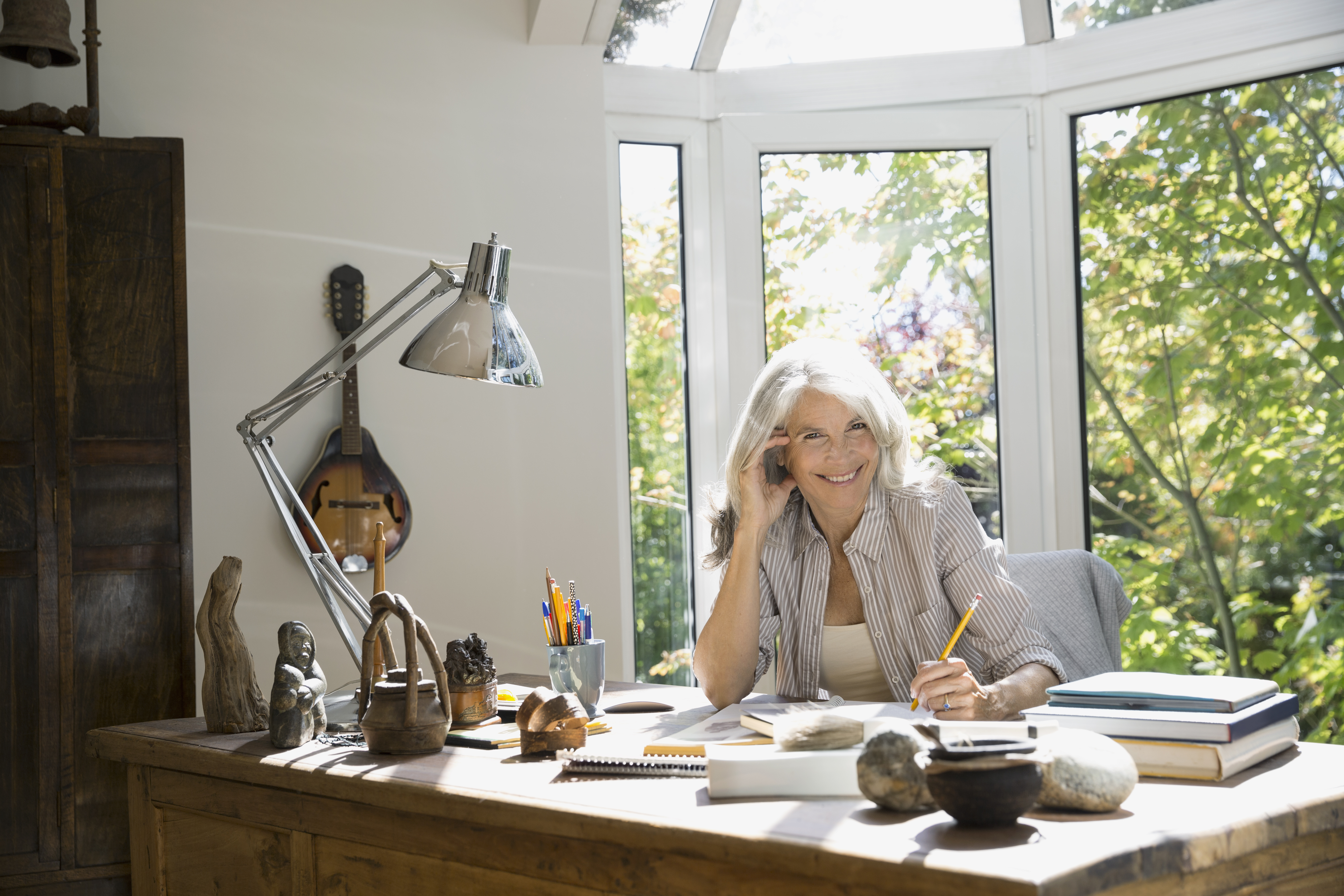 Portrait of senior woman writing in home office