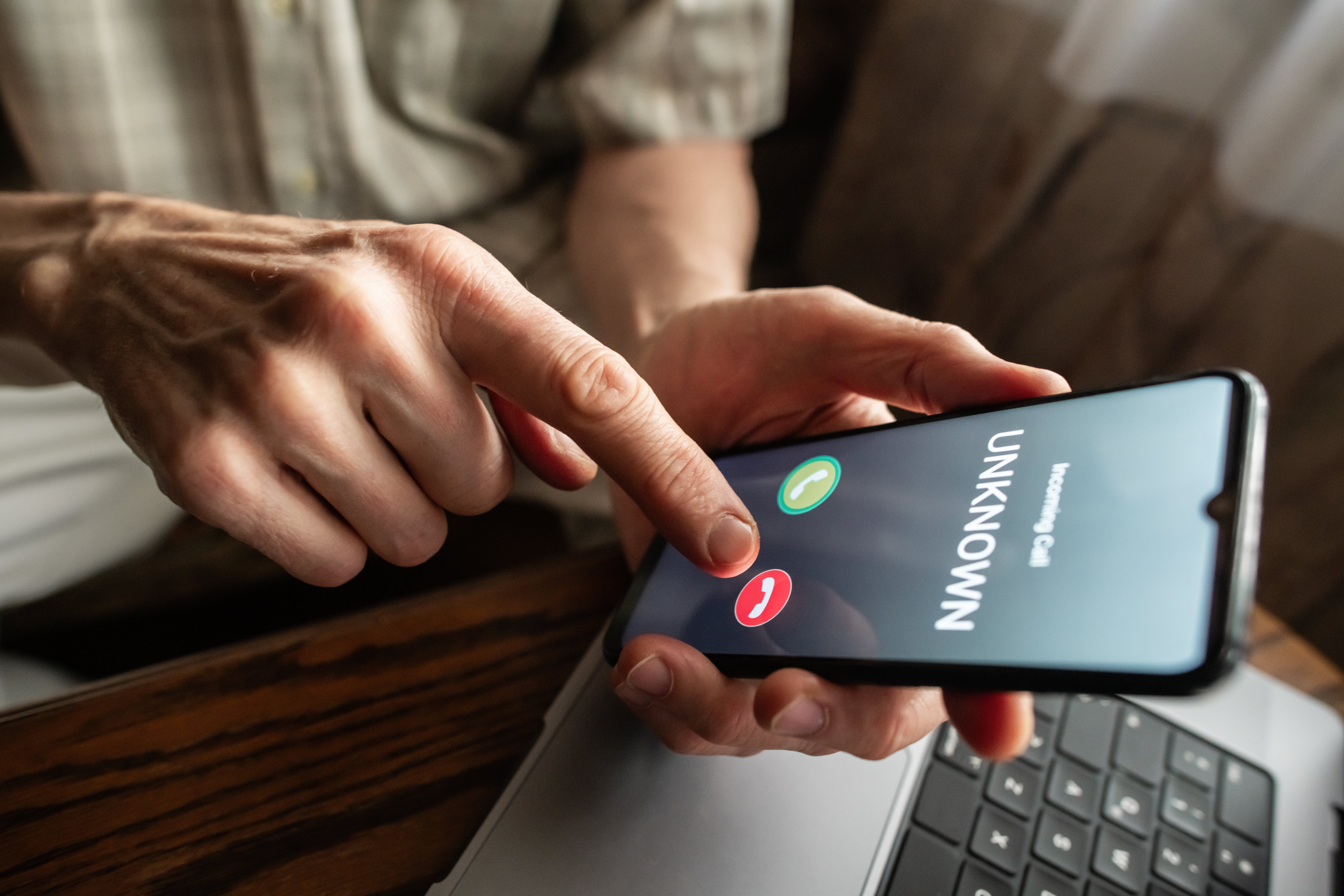 Senior man refuses to answer to a call from unknown number. Scam and fraud prevention with smartphone concept.
