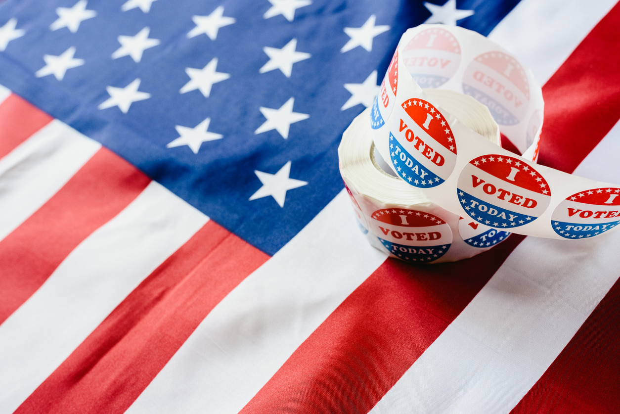 I vote today stickers roll, in US elections on American flag.