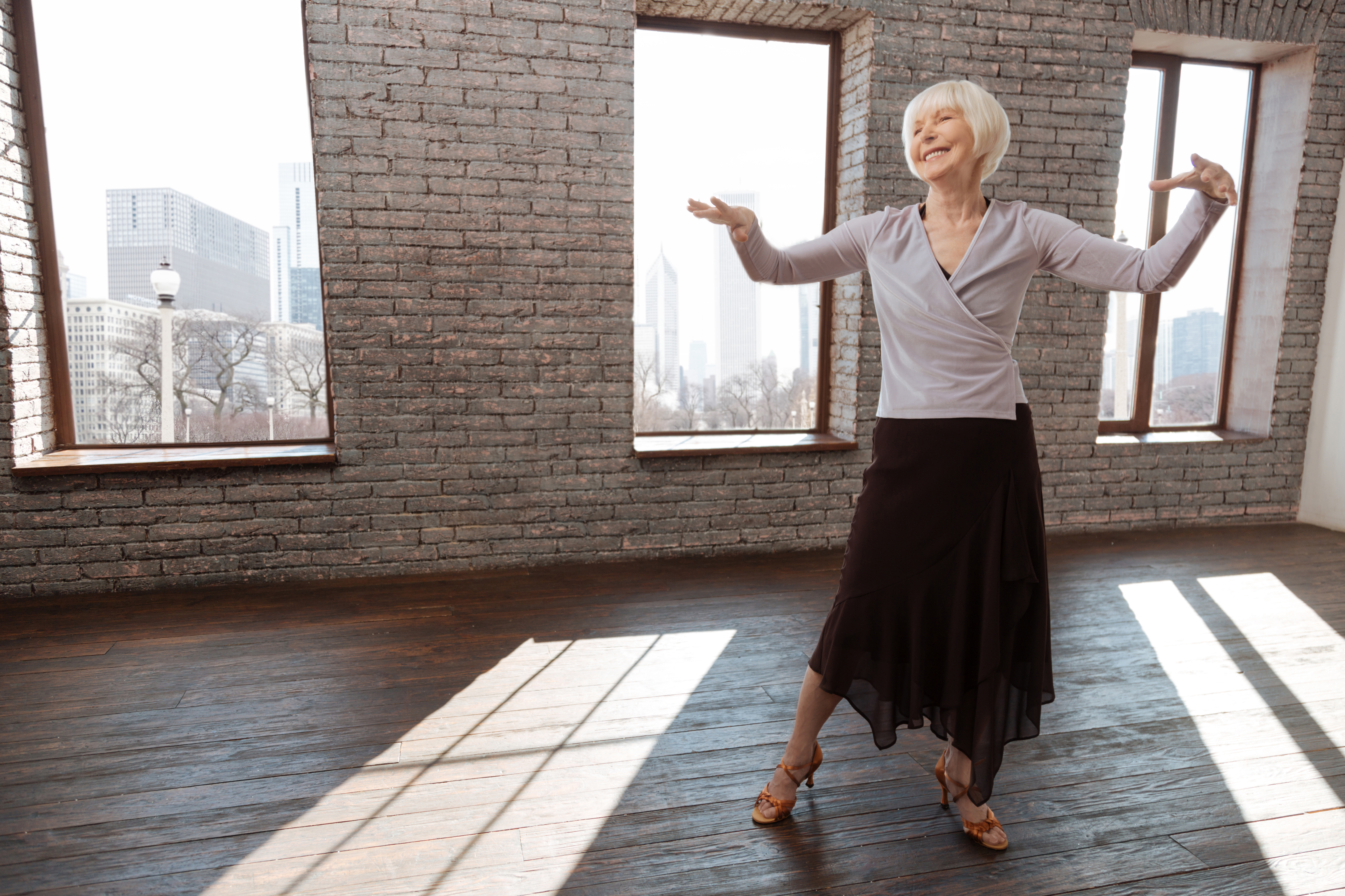 Upbeat aged woman dancing in the ballroom