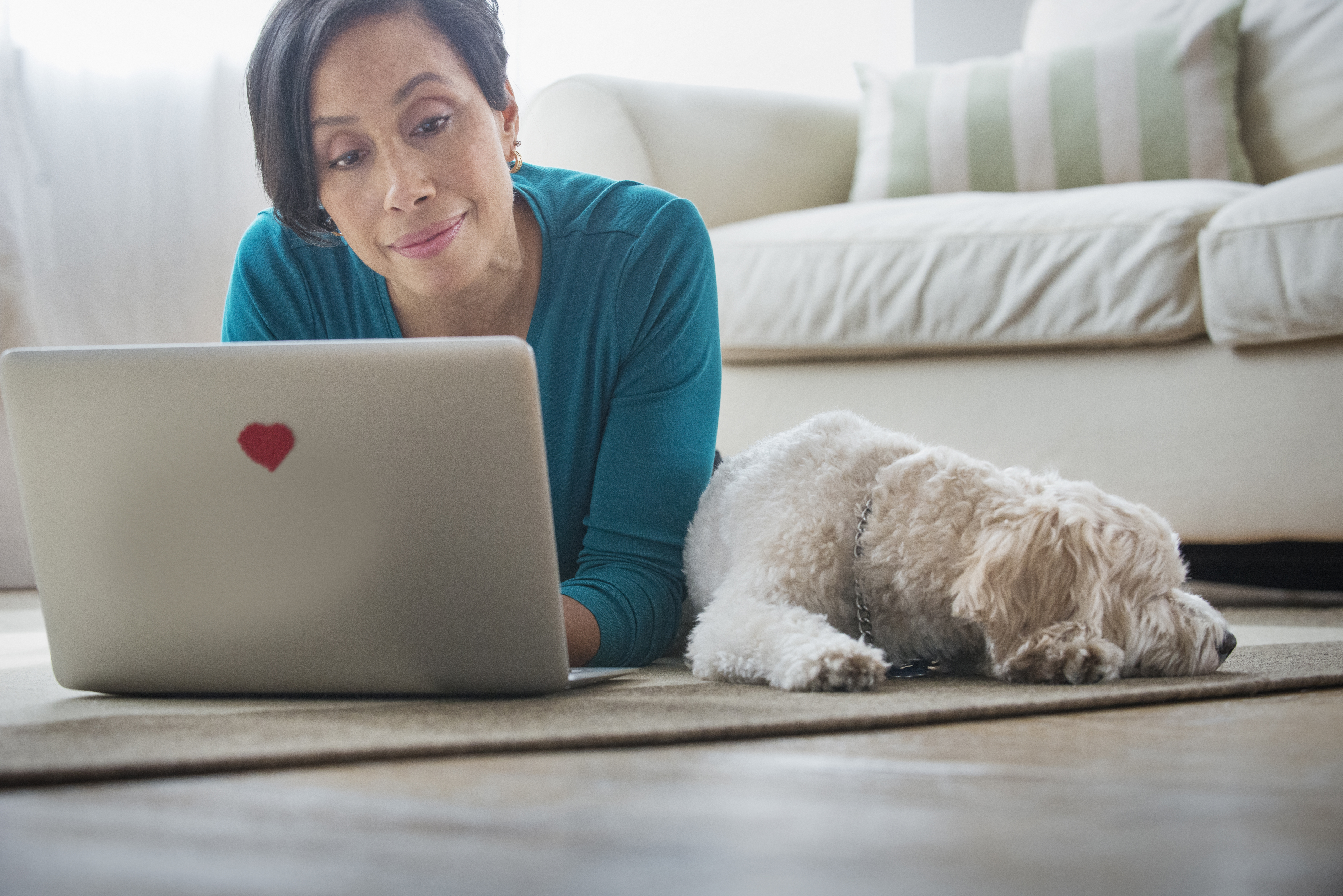 Black woman using laptop with dog