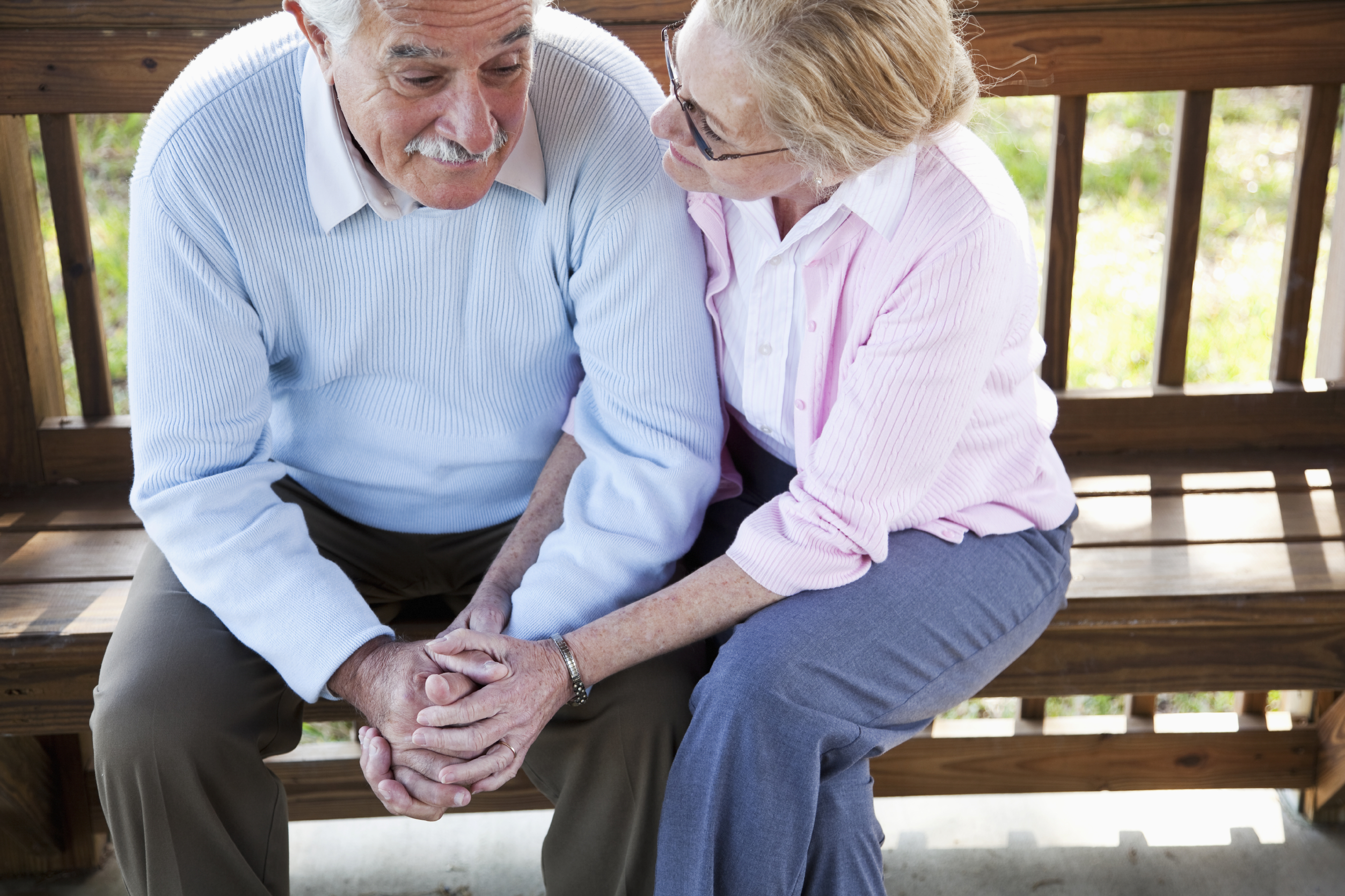 Senior woman consoling sad husband.