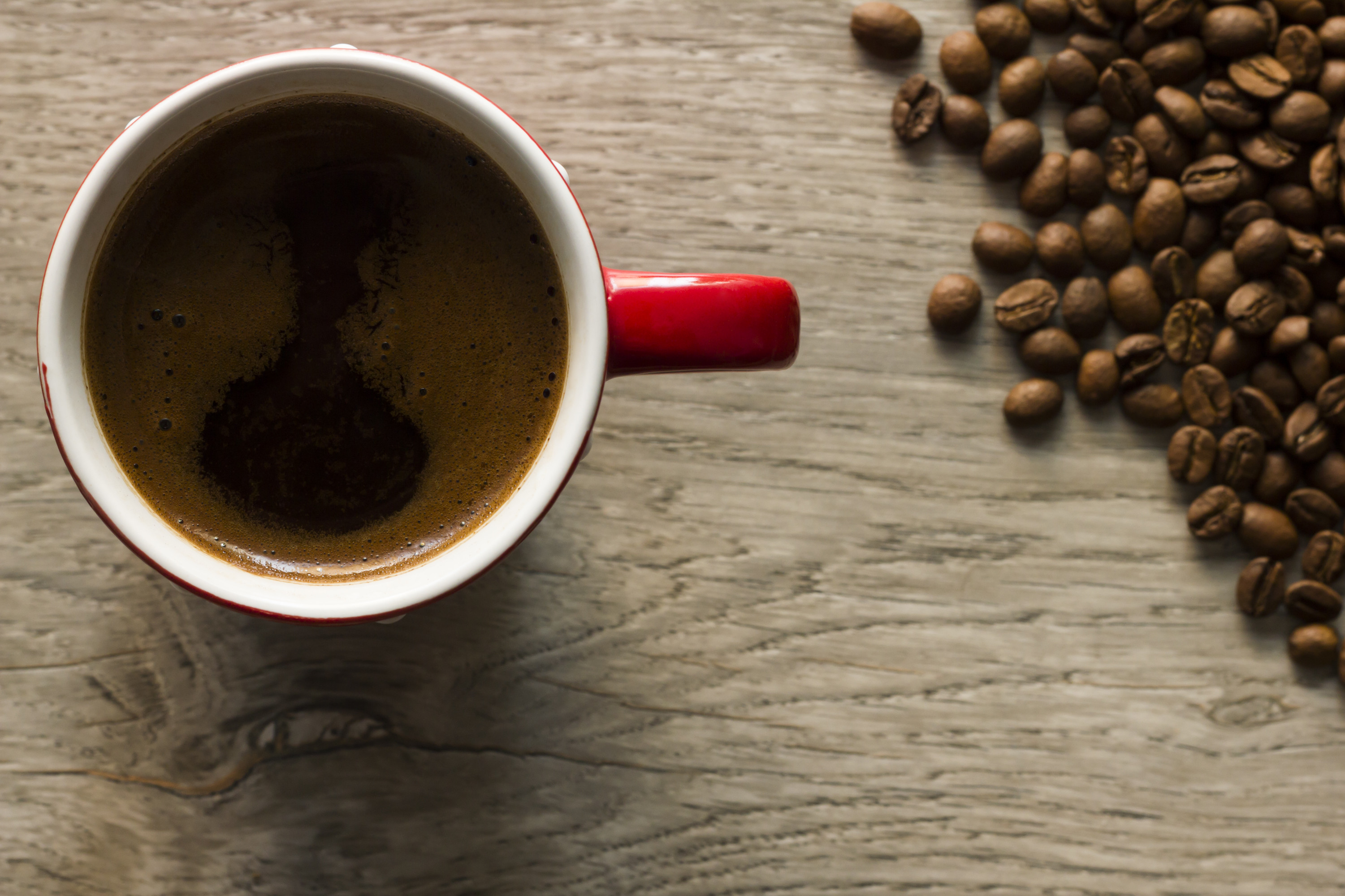 Cup of coffee and coffee beans viewed from directly above