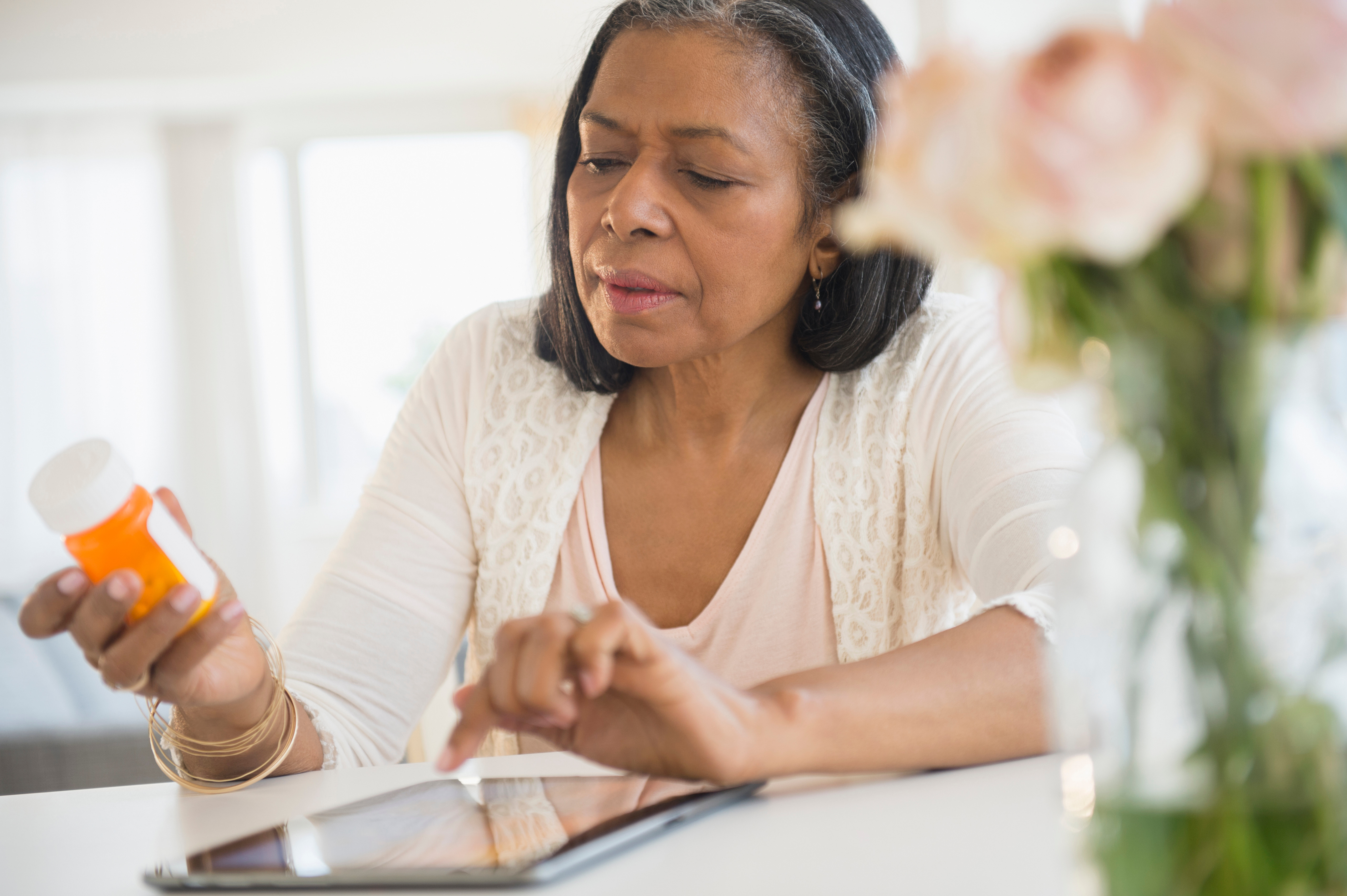 Woman researching medication on tablet computer