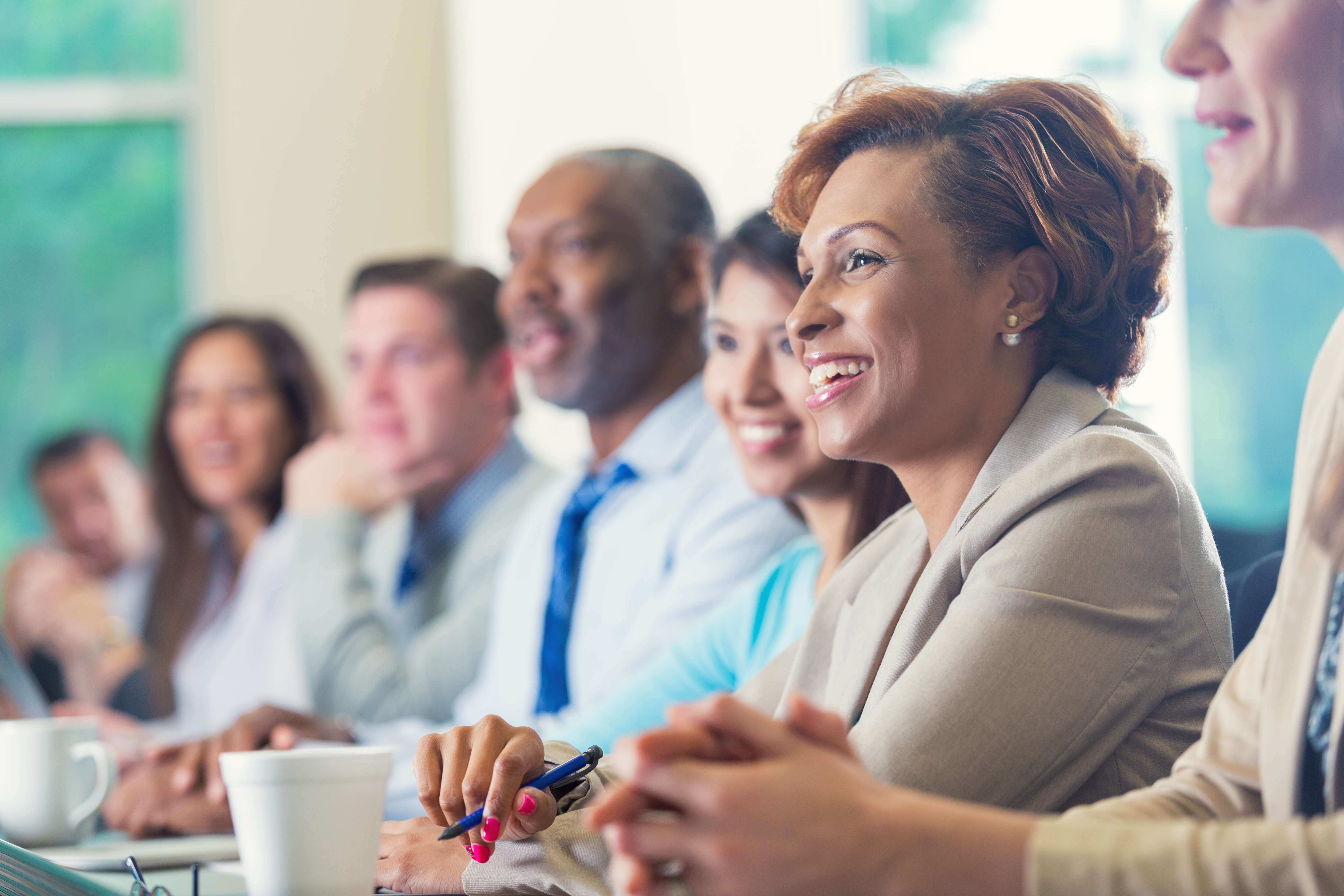 African American businesswoman listening to seminar speaker at business conference