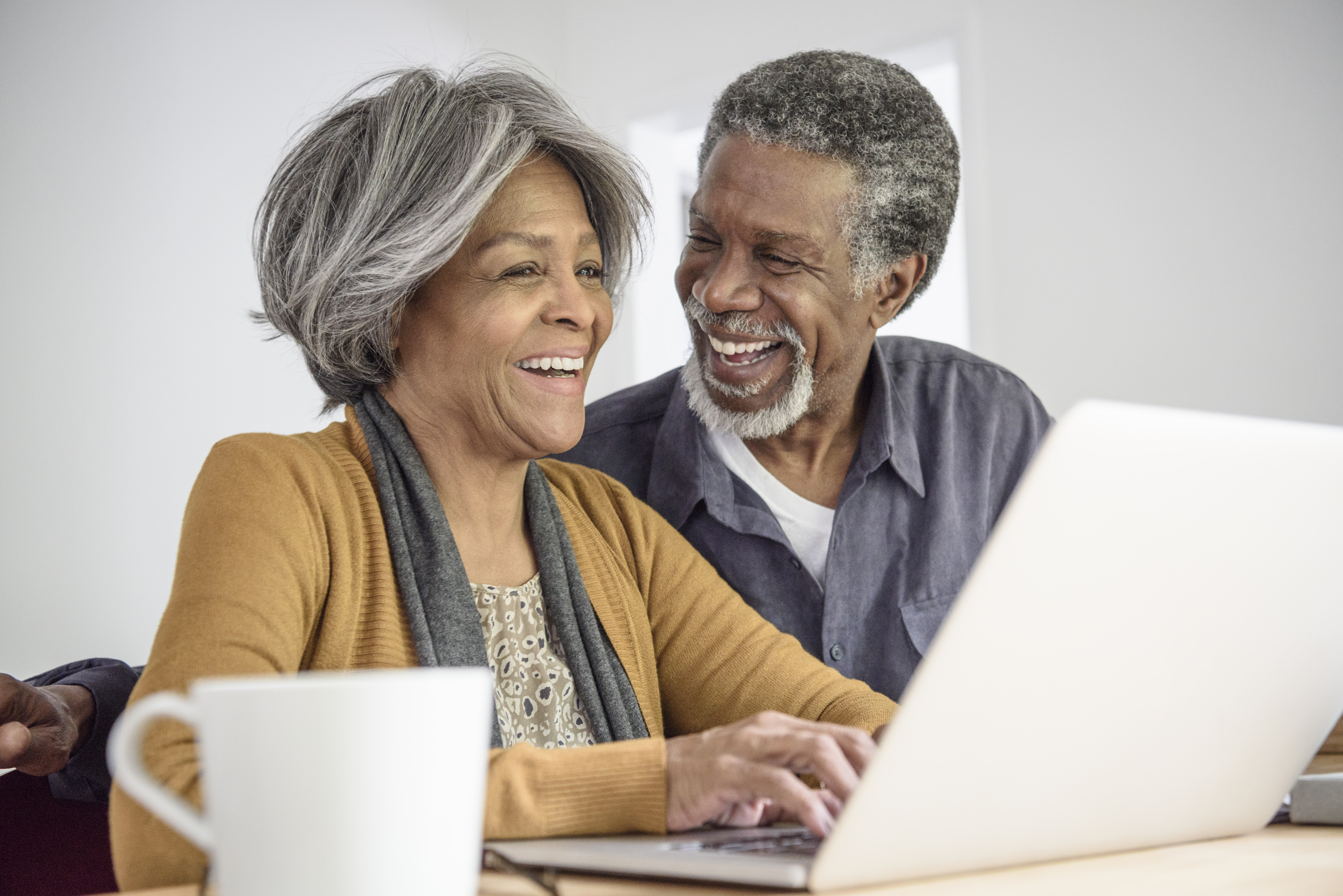 Senior African American couple using laptop and laughing