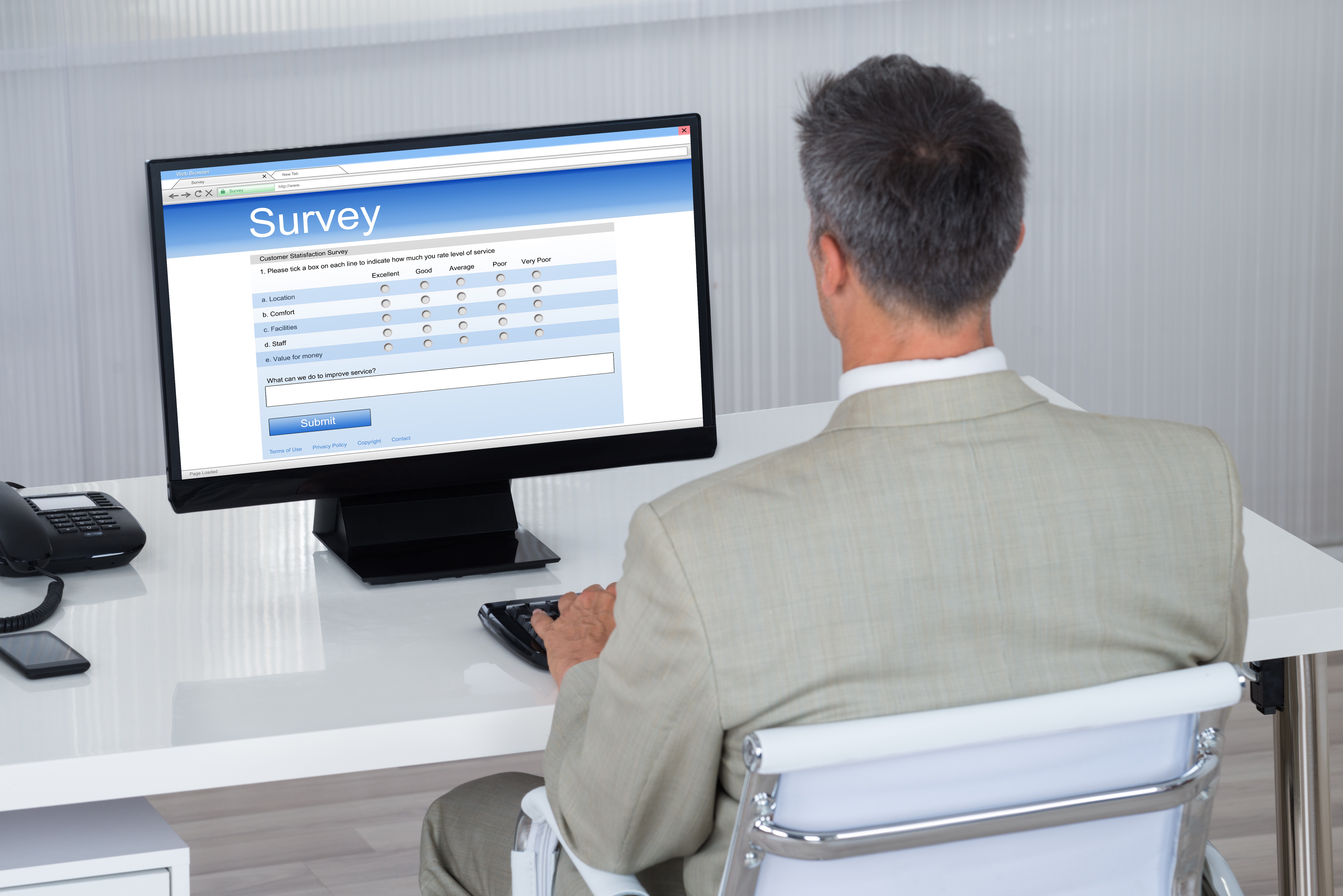 Businessman Filling Survey Form On Computer At Desk