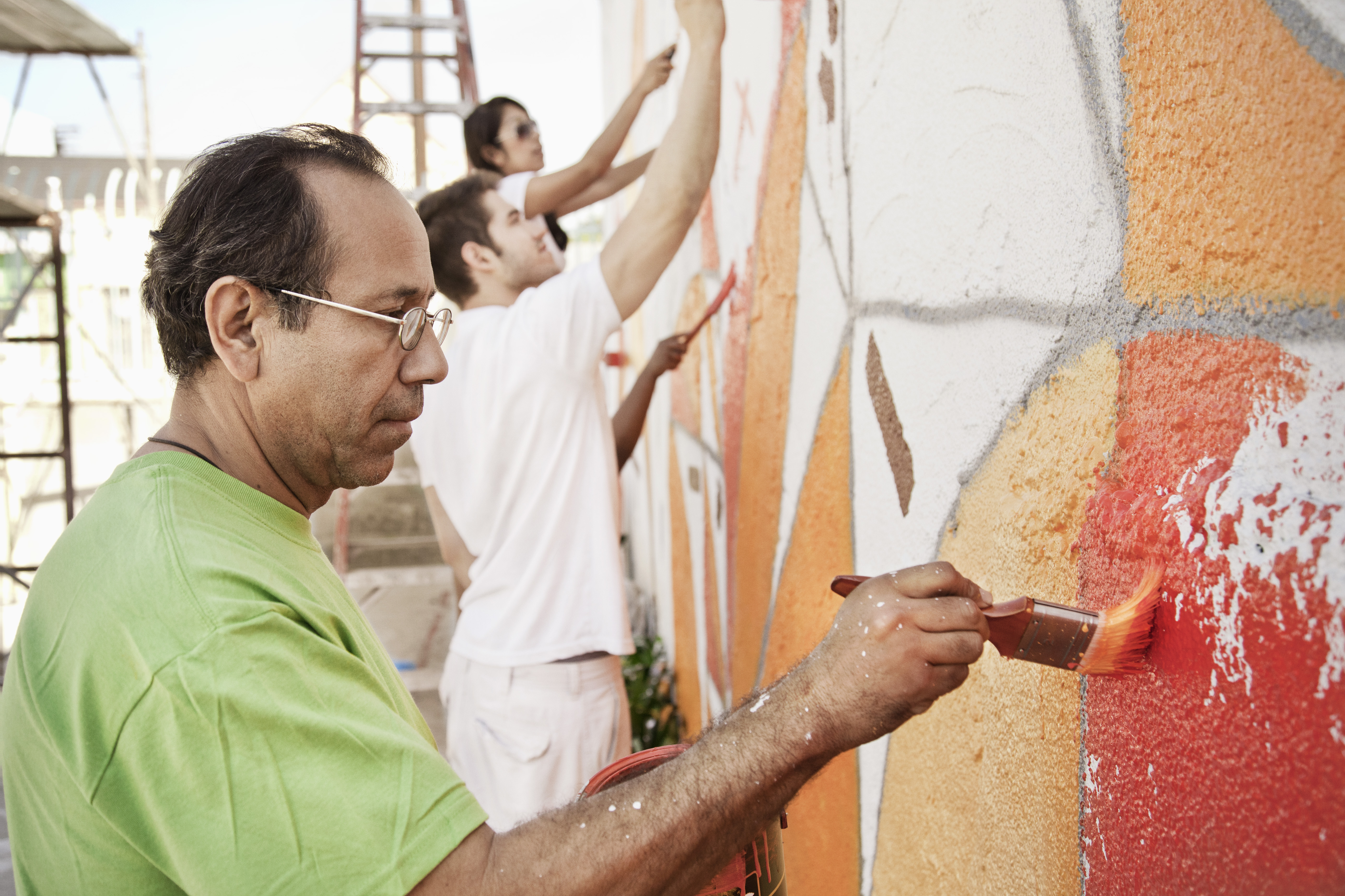 Volunteers painting wall together